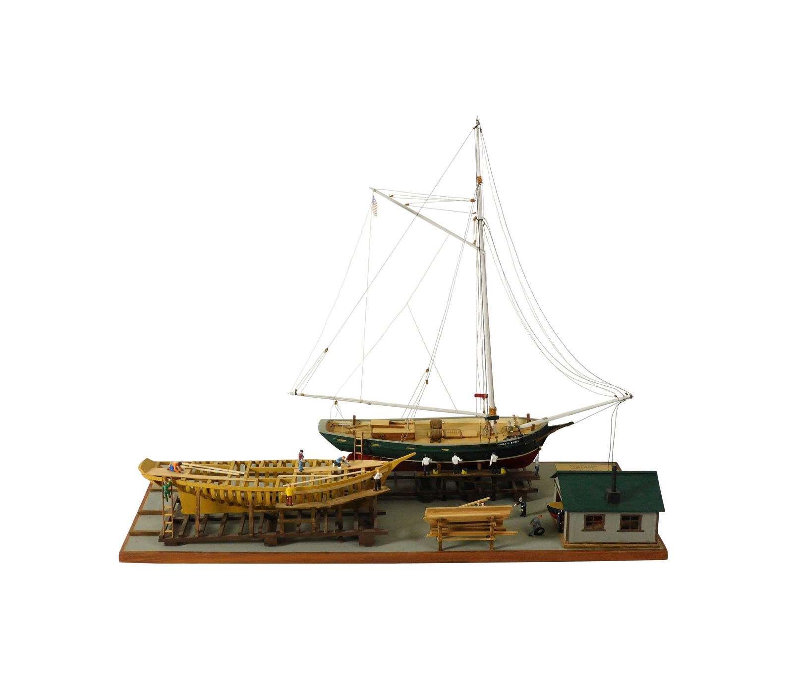 Detailed Model of The Down East Shipyard: 20th C. Made by William C. Baum. Depicts the Boston well smack EMMA BERRY. Excellent detail with individually planked deck. Single mast flying the American flag. Also shows a similar ship being constr