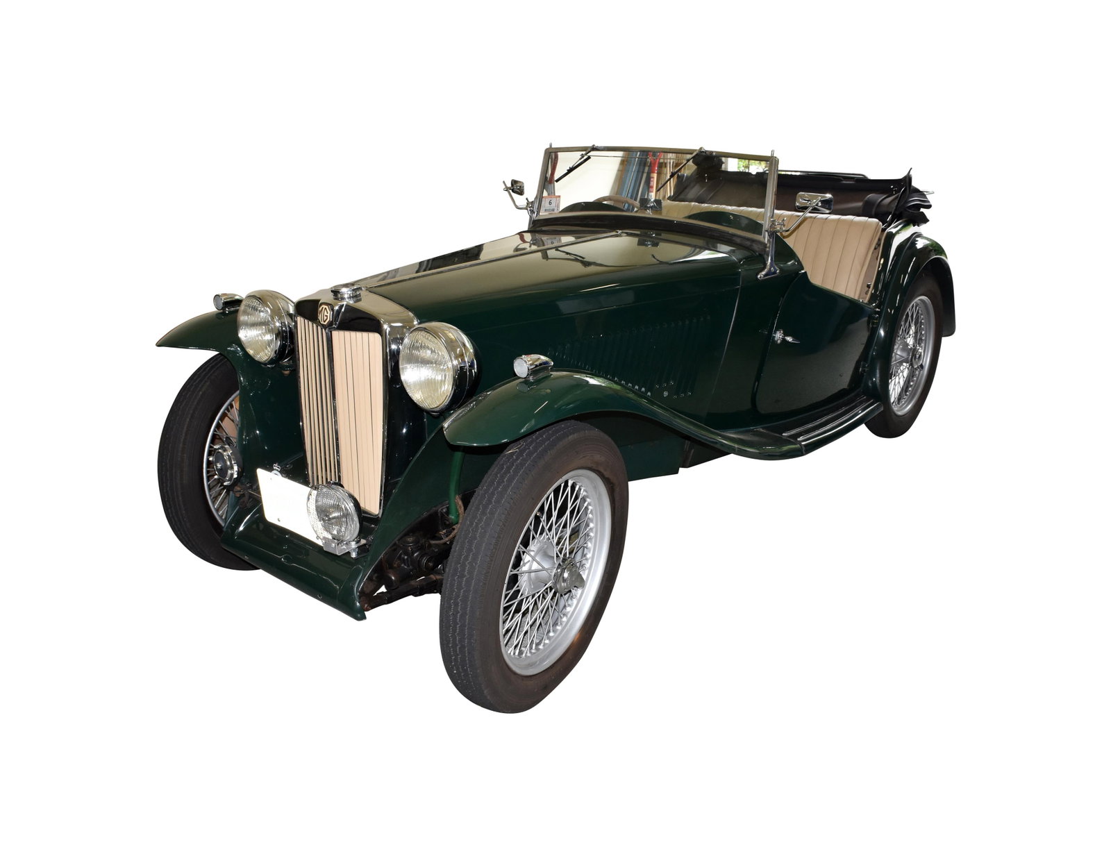 1948 MG TC: VIN: TC7051. 4 Cylinder manual transmission roadster. British racing green exterior, tan interior, black canvas top, and wire wheels. Provenance: New England Auto Auction 2023, Lot 152.1 The vehicle