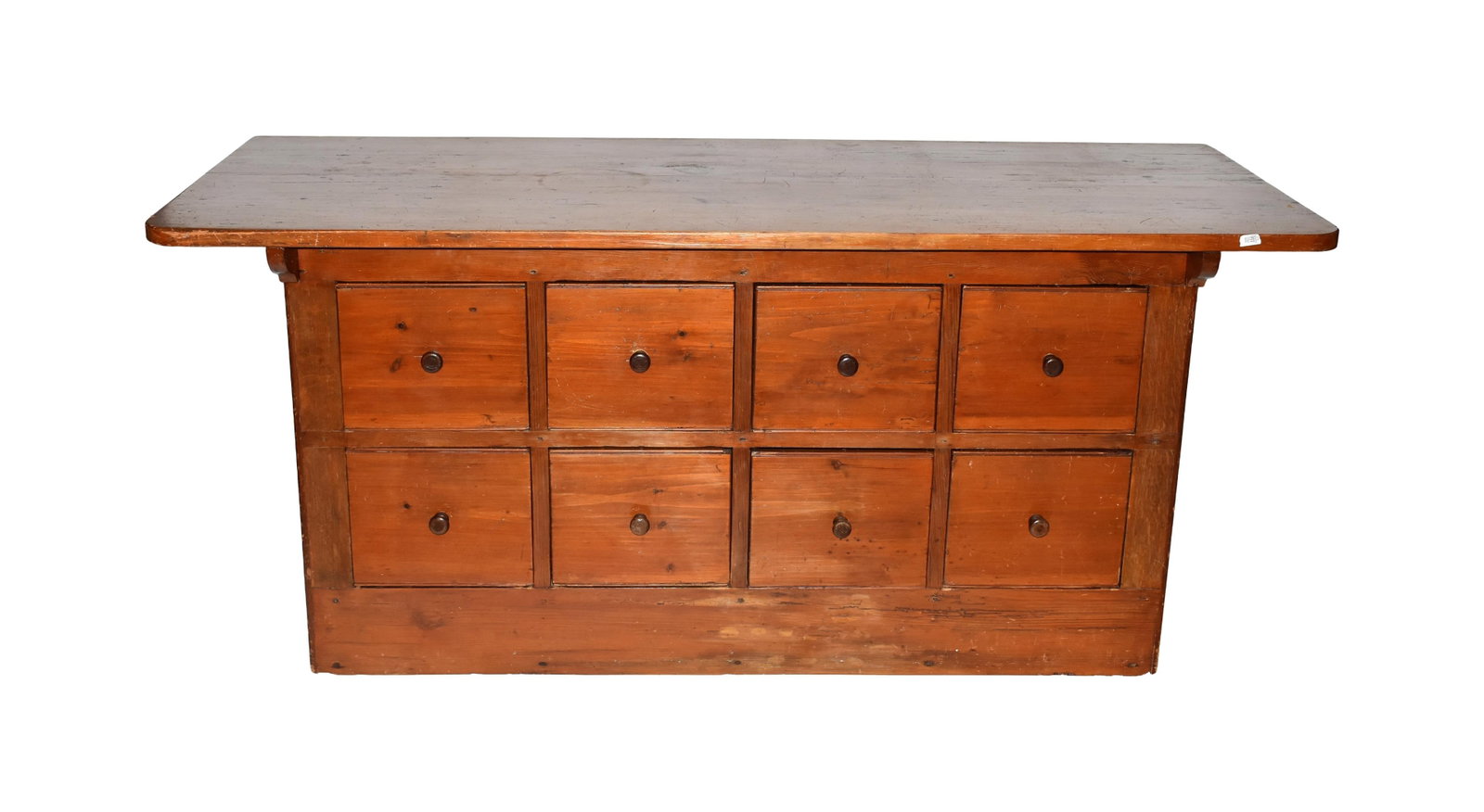 Eight-Drawer Tailor Counter: 19th C. Pine. Turned pegged-in knobs. Cutout ends. 32 1/4" high x 73 1/2" wide x 29 3/4" deep. Provenance: From the collection of Charles and Helen Upton of Troy, New York.Refinished condition. Age