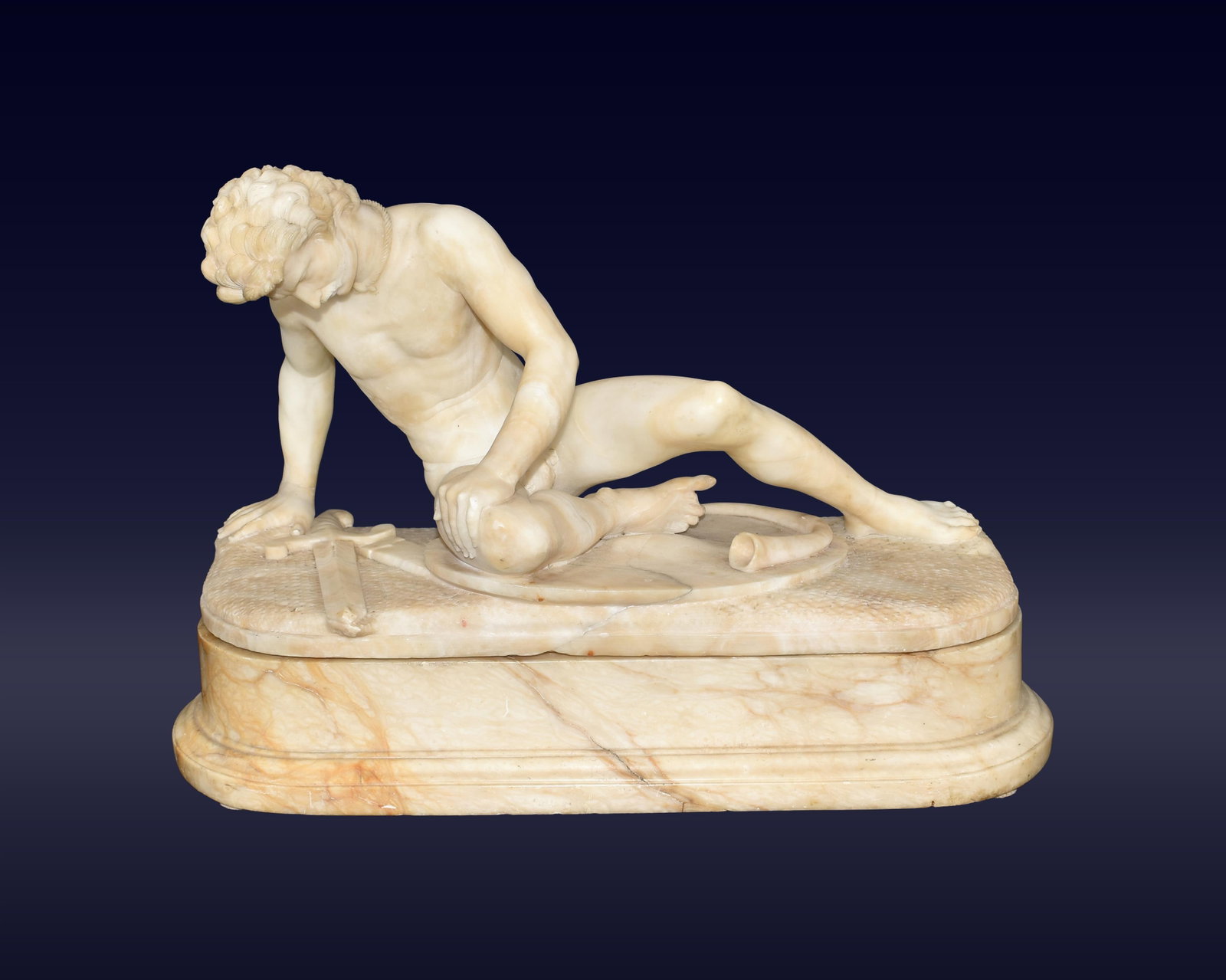 Grand Tour Carved Alabaster Sculpture: Late 19th C. "The Dying Gaul". Carved figure on alabaster base. Two pieces. 12" high x 17 3/4" wide x 6 1/2" deep. 40.8 lbs.Shows minor cracking to alabaster. IMPORTANT- Please note: all items are