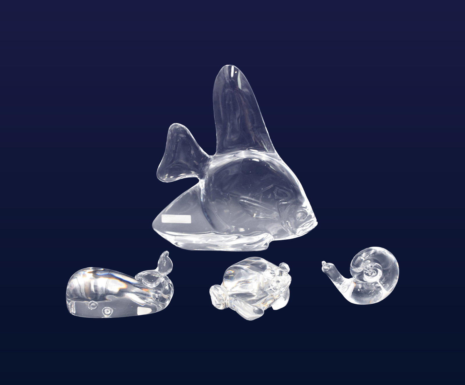 (4) Steuben Glass Figures: 20th C. All signed on bottom. To include: (A) Large goldfish. 10 3/4" high x 10" wide. (B) Whale. 3" high x 5" wide x 2 1/2" deep. (C) Frog. 2 1/2" high x 4" wide x 4 1/2" deep. (D) Snail. 3" high x 3