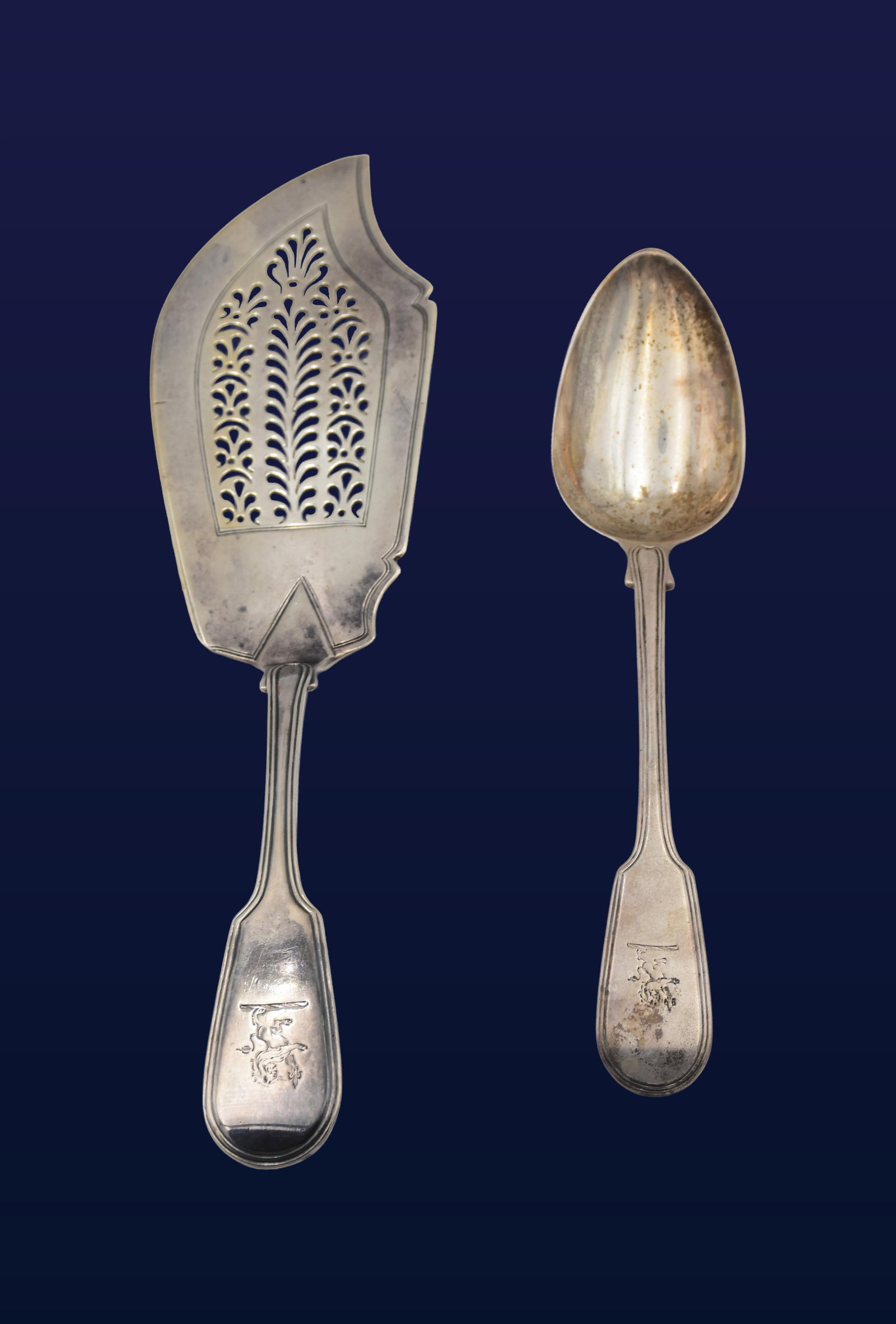 Sterling Silver Fish Server & Spoon: Early 19th C. British maker. To include: (A) Fish server with pierced decorative blade. Etched lion crest on handle. 12" long x 3" wide. (B) Serving spoon. 8 3/4" long. 7.43 total ozt. (A) Very good