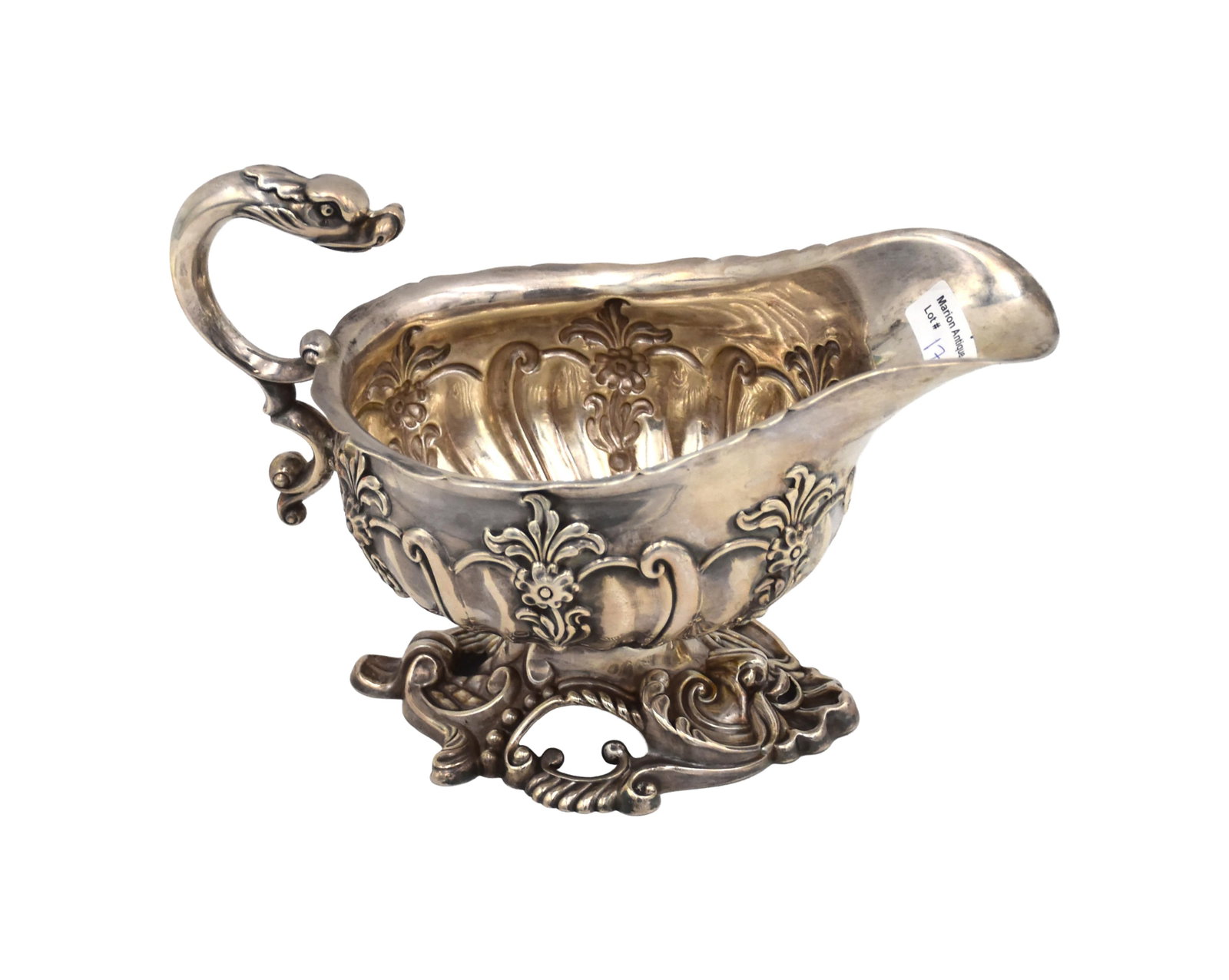Georgian Sterling Silver Sauce Boat: Late 18th/Early 19th C. Repousse floral and scroll decoration with dragon or serpent-form handle. Engraved with a crest to body. 16" high x 7 1/2" wide x 4" deep. 14.23 ozt.Good condition consistent
