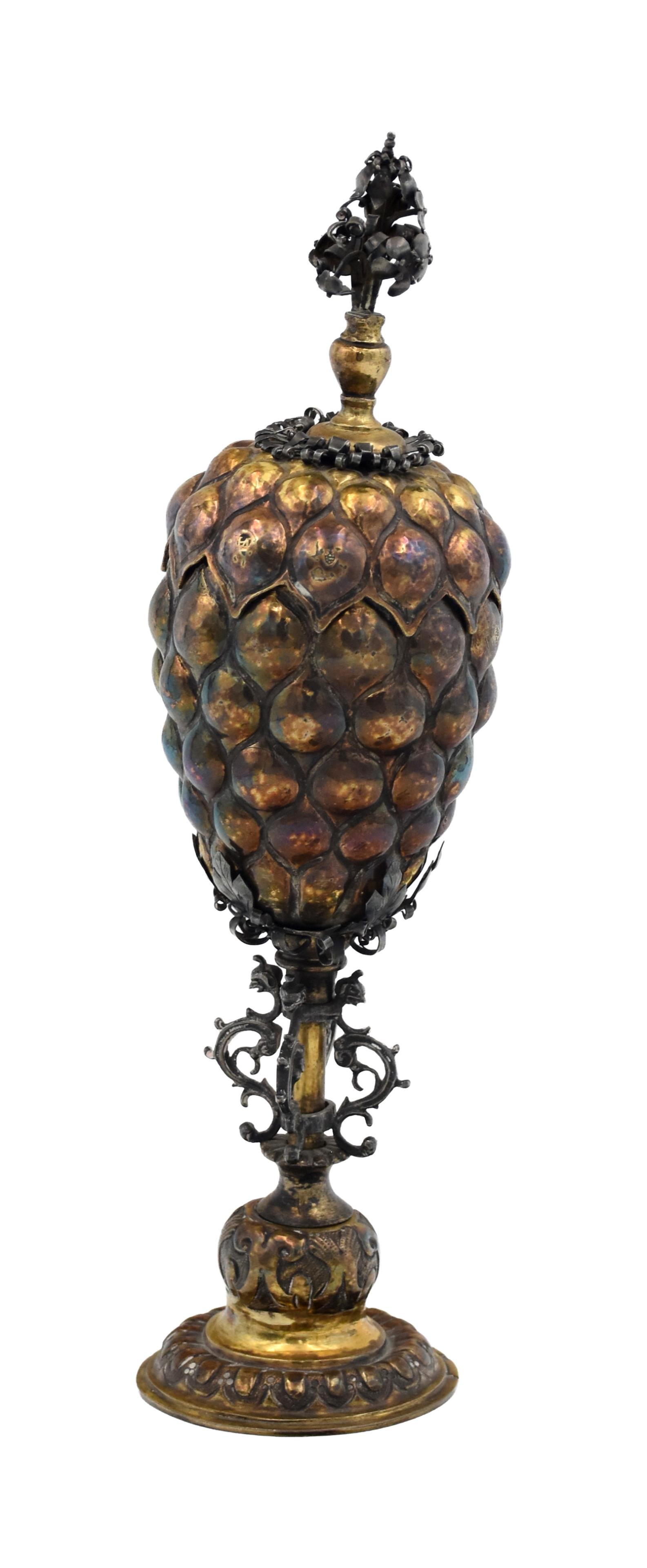 German Cup and Cover: Ca. 1690. Made in Augsburg, Germany. Gilt silver. Typical lobed form and body with a floral cresting. Maker stamp: "HA Conjoined". 10 1/4" high x 2 3/4" diameter. 8.97 ozt.Slight tilt. Minor wear to g