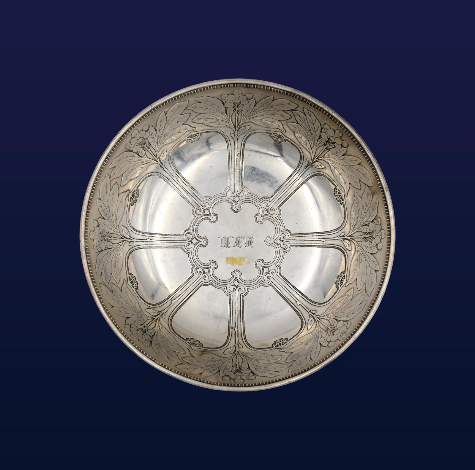 Tiffany & Co. Sterling Silver Bowl: Art Nouveau style. Berry clusters and leaves around inside bowl, beaded rim and central monogram. Stamped "Tiffany & Co. Makers, 925-1000, M" code on bottom. 3 1/4" high x 9 1/2" diameter. 19.57