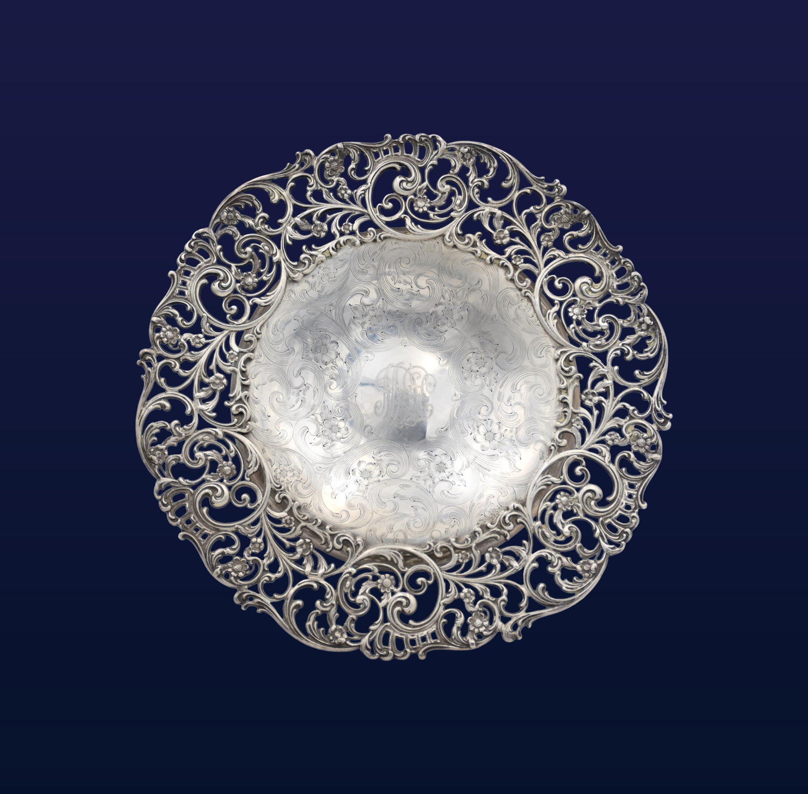 Shreve, Crump & Lowe Footed Tray: Early 20th C. Ornate open work embossed floral and scroll design. Engraved floral design center. Stamped by maker, sterling and an eagle with words trade mark on verso. 1 1/4" high x 14" diameter.