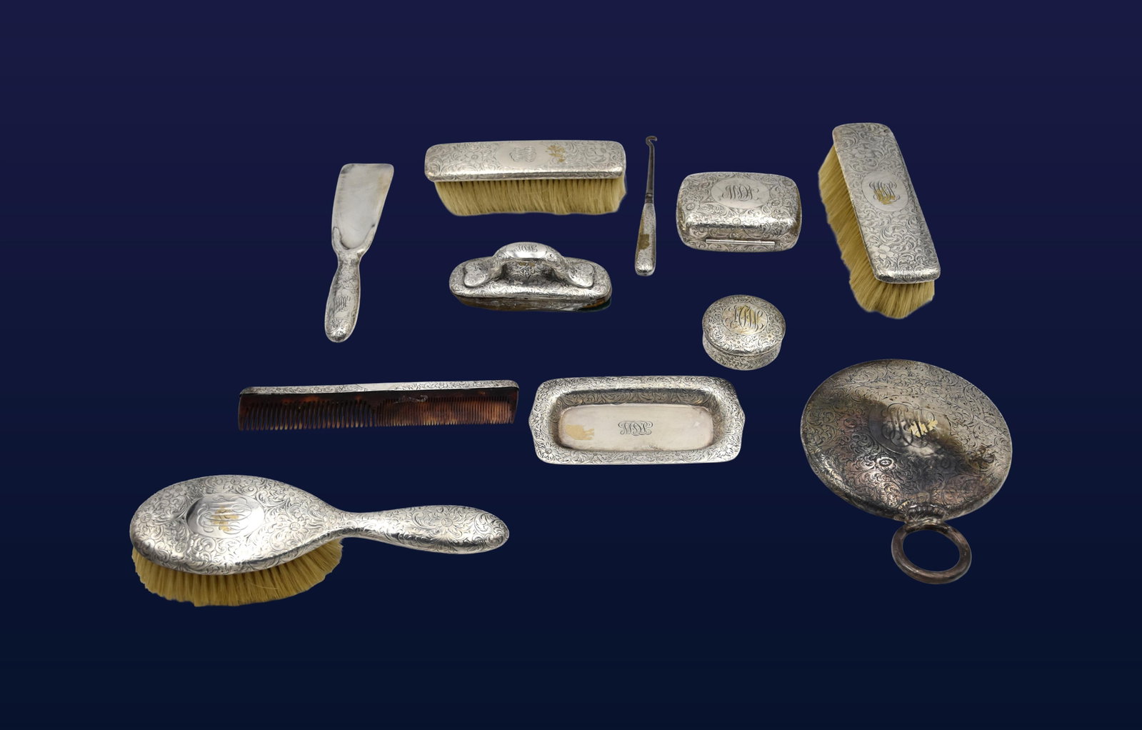 (11) Piece Tiffany & Co. Vanity Set: Early 20th C. Engraved floral design. Stamped "Tiffany & Co. makers, sterling silver, 925-1000, M" on some pieces. To include: (A) Hand mirror. 5 1/4" diameter. (B) Two brushes. 6"-7" long. (C)
