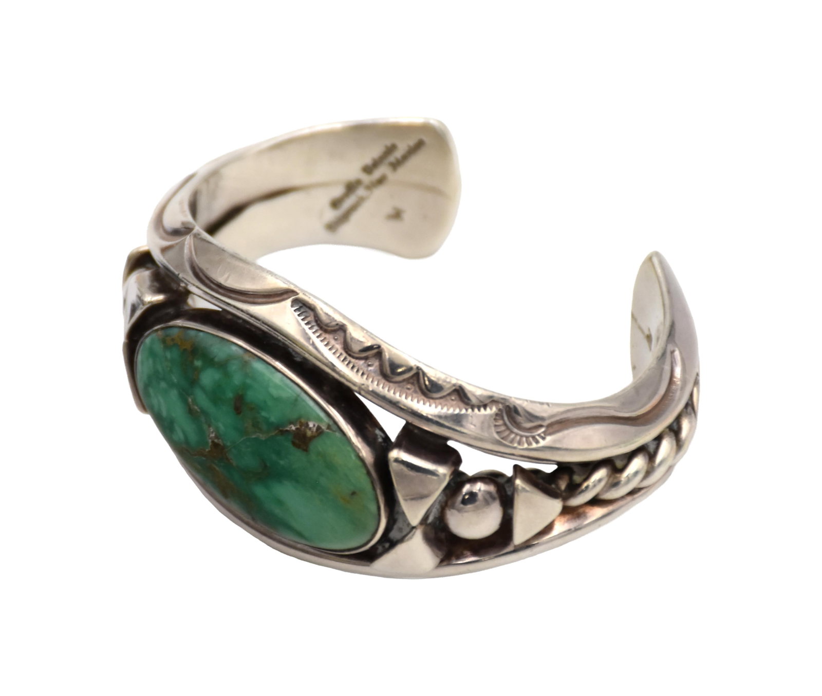 Sterling and Carico Lake Turquoise Bracelet: 20th C. Handmade by Orville Tsinnie (1943-2017), Shiprock, New Mexico. 1 1/2" high x 3 1/2" wide x 2" deep. Comes with original receipt. Good condition. IMPORTANT- Please note: all items are sold as