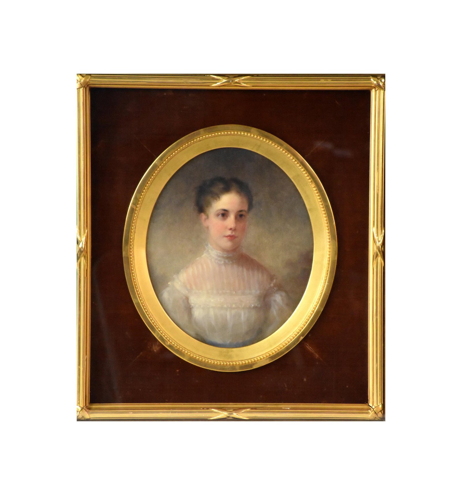 Portrait of a Young Girl: 19th C. Oil under glass. Depicts a young girl wearing a white lace dress. Unsigned. In an exceptional carved and gilded frame with oval center. Oval image: 11" high x 9" wide. Interior frame: 20"