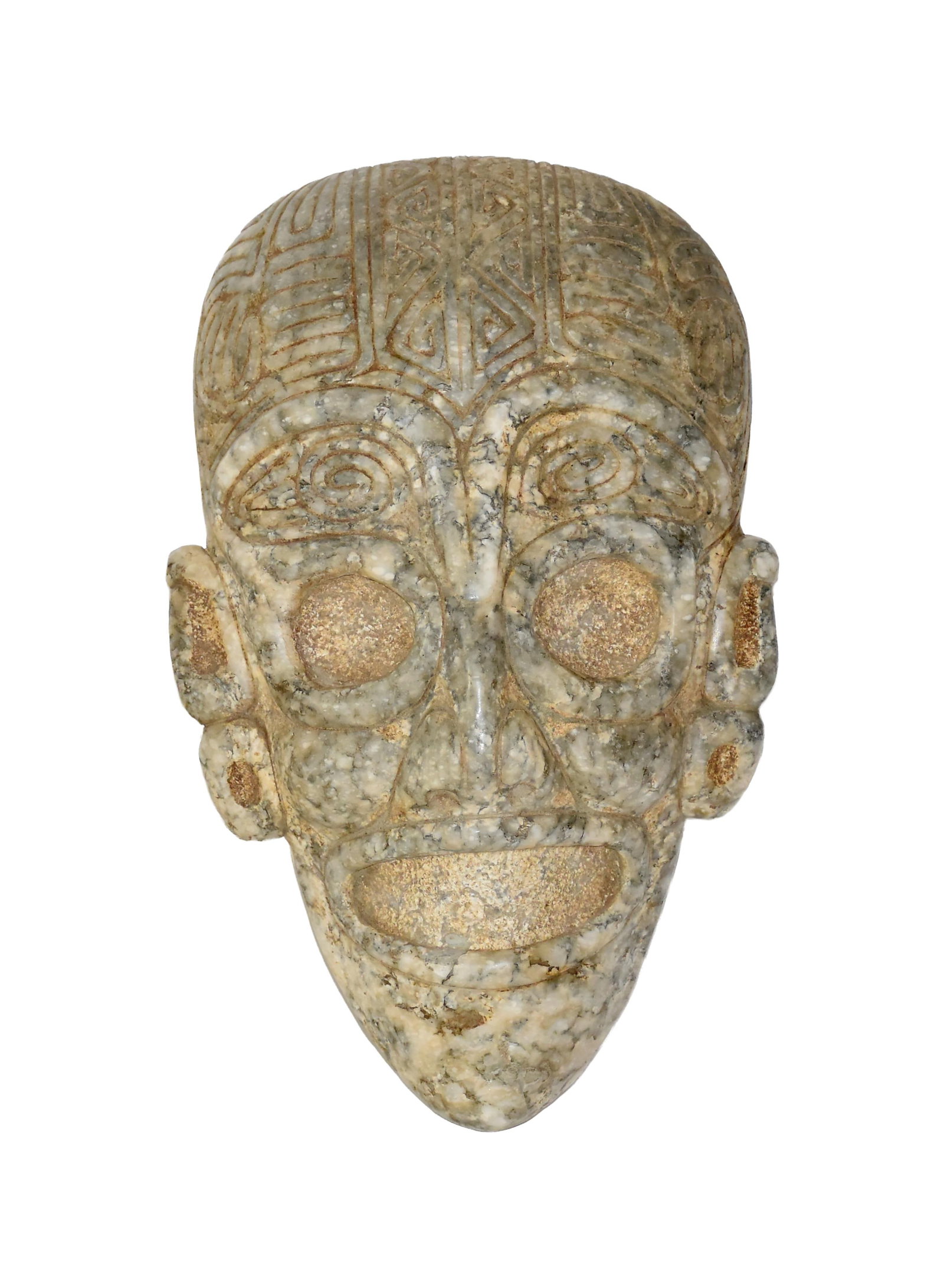 Taino Marble Mask: Ca. 600-1500 AD. White marble with contrasting black inclusions. 10 1/2" high x 6 3/4" wide. Features are well-carved with embossed eyes and mouth surrounds, a tabular erect forehead and an arching, w