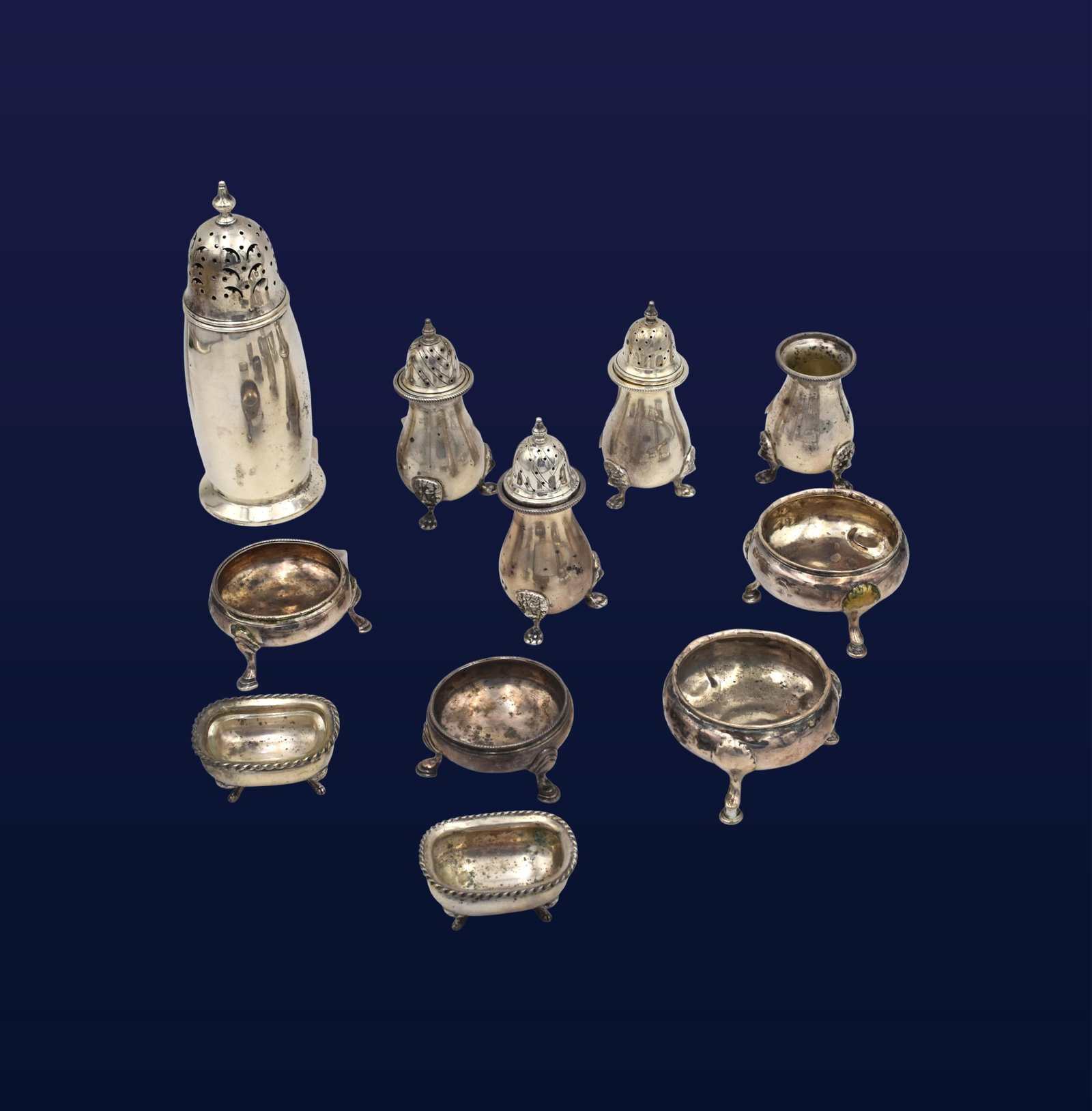 (11) Misc. Sterling Salt, Pepper and Sugar Shaker: Late 19th/early 20th C. To include: (A) Sugar shaker. Pierced lid with finial top. 7" high. (B) Three lidded, footed pepper shakers plus one missing lid that could be used as a bud vase. Lion head fee