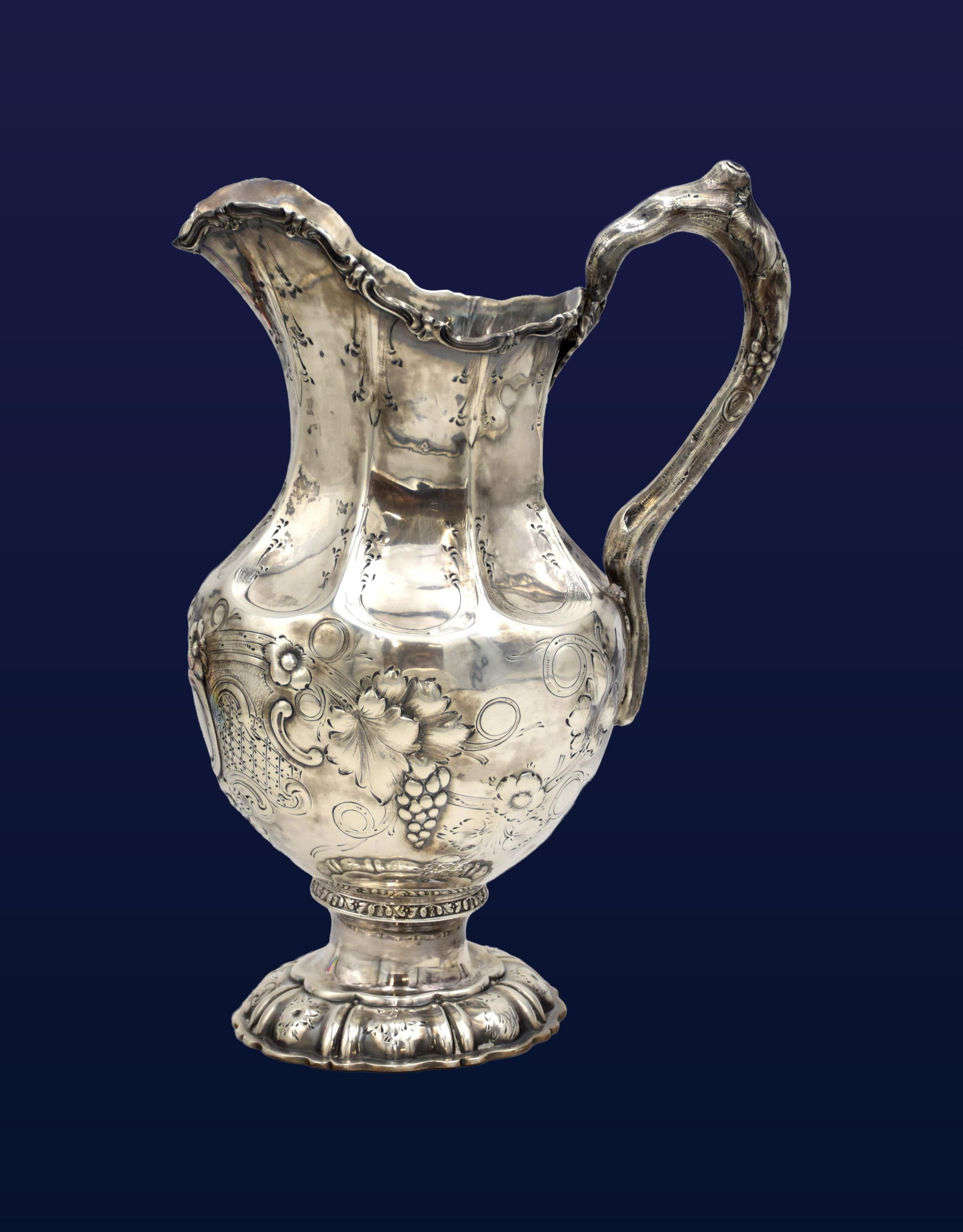 Coin Silver Pitcher: Late 19th C. W. Gale & Son. Repousse grapevine decoration and ornate detailing. 12" high x 8 1/2" wide from spout to handle x 4 3/4" diameter at base. 26.37 ozt.Age appropriate wear. Monogrammed. IMPO