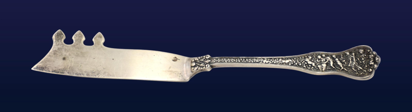 Tiffany & Co. Cheese Knife: Late 19th C. Olympian pattern. Stamped "Tiffany & Co. Sterling". 7 1/4" long. 1.78 ozt.Some tarnish and surface scratches consistent with age and use. IMPORTANT- Please note: all items are sold as