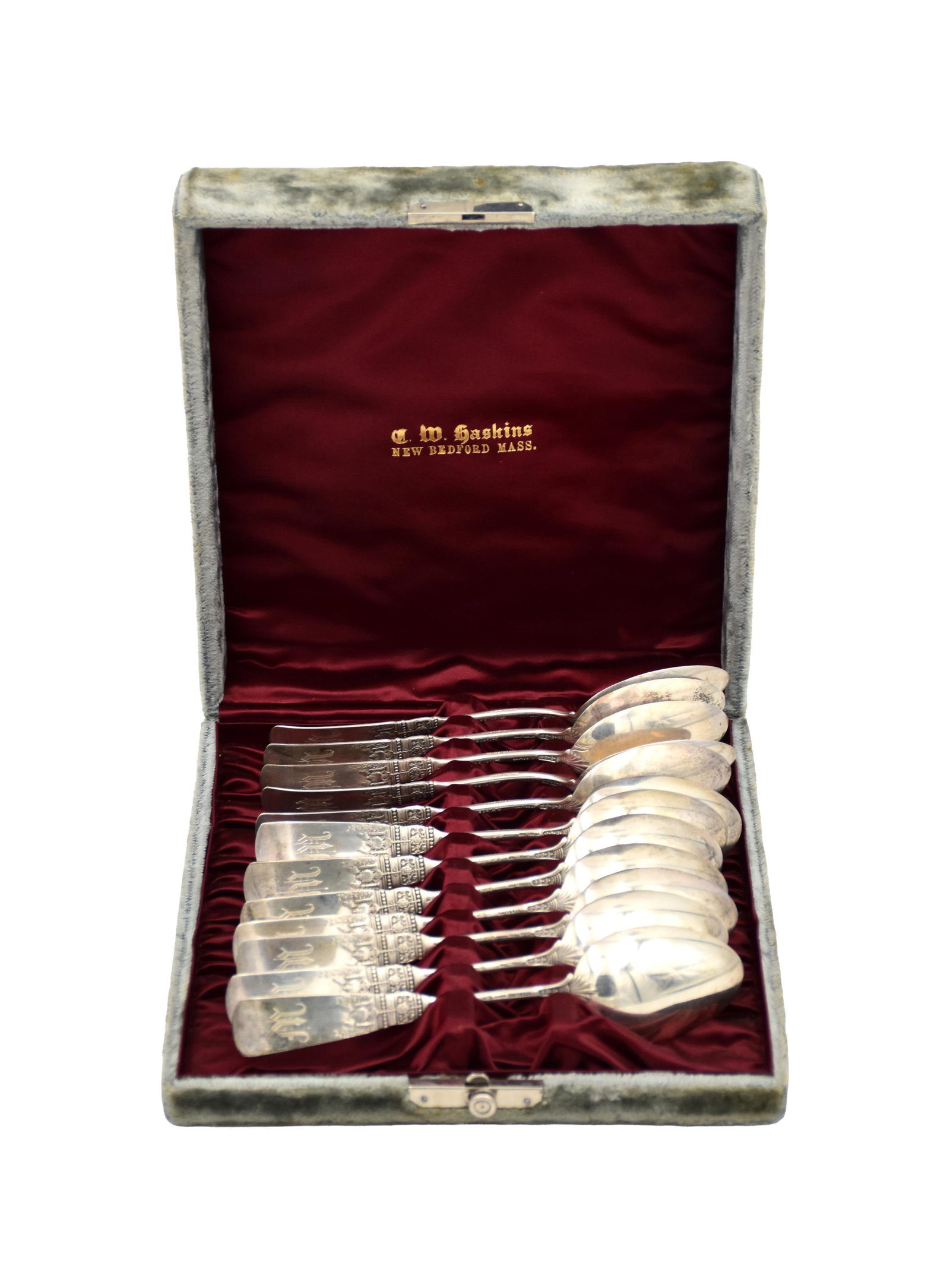 (12) Sterling Silver Spoons: Late 19th/Early 20th C. Stamped "C.M. Hastings Sterling" on verso. Raised figural scene with a woman in period dress, floral and scroll decoration, and a beaded collar. 5 3/4" long. In a velvet case