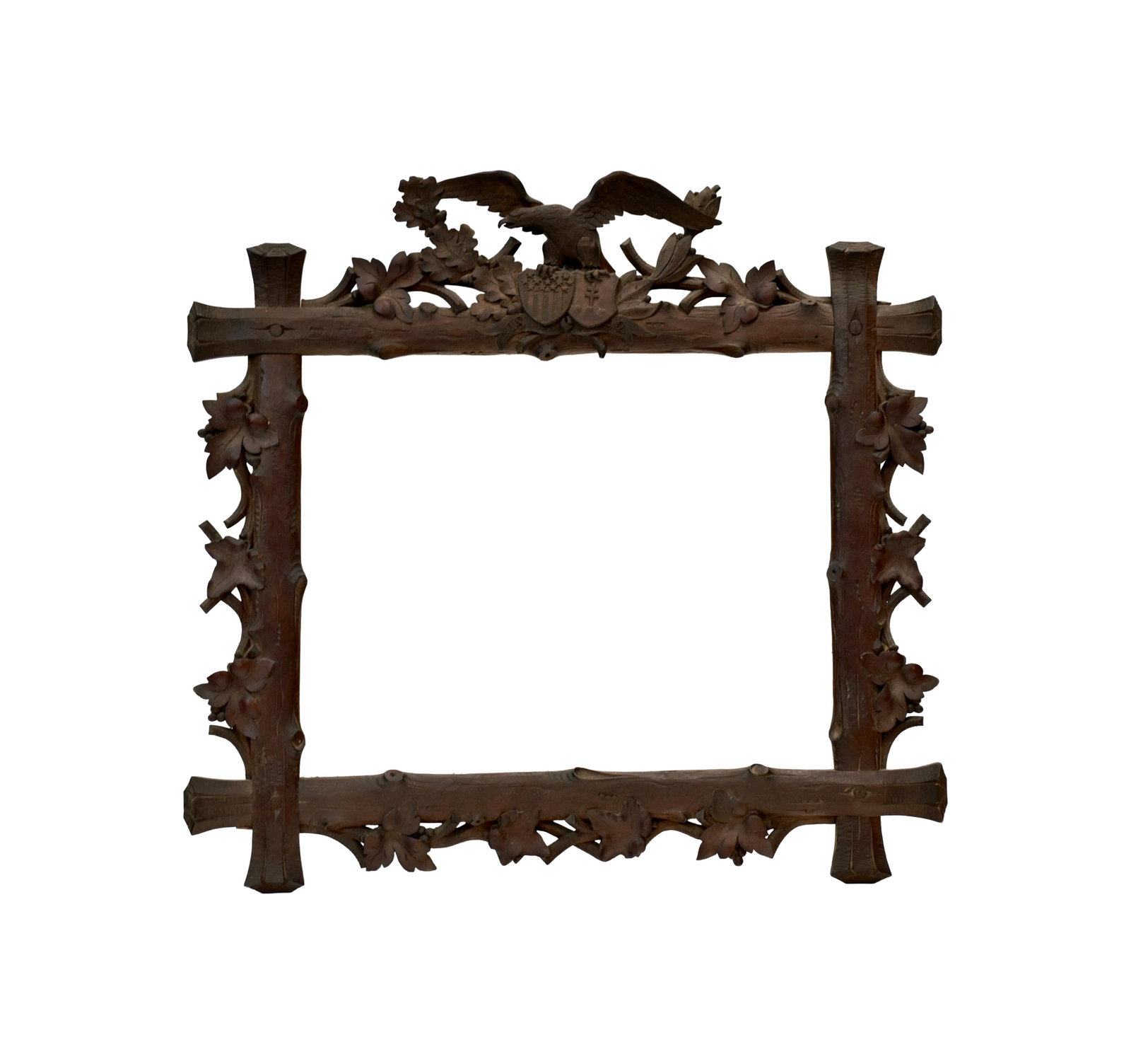 Carved Folk Art Eagle Frame: Ca. 1892. Walnut. Eagle is holding an American shield with stars and stripes and a shield with a cross on a hill. Twig leaf and berry motif throughout. 21 1/2" high x 23" wide. Exquisite carving.