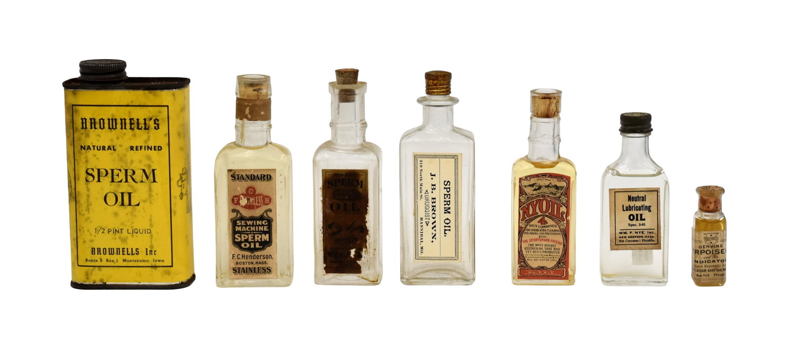 Collection of (7) Oil Containers: 19th/20th C. To include: (A) Can of Brownell's Natural Refined Sperm Oil with contents. 1/2 pint. 5 1/4" high x 2 3/4" wide x 1 1/2" deep. (B) Nyoil glass bottle with cork stopper. With contents. 4