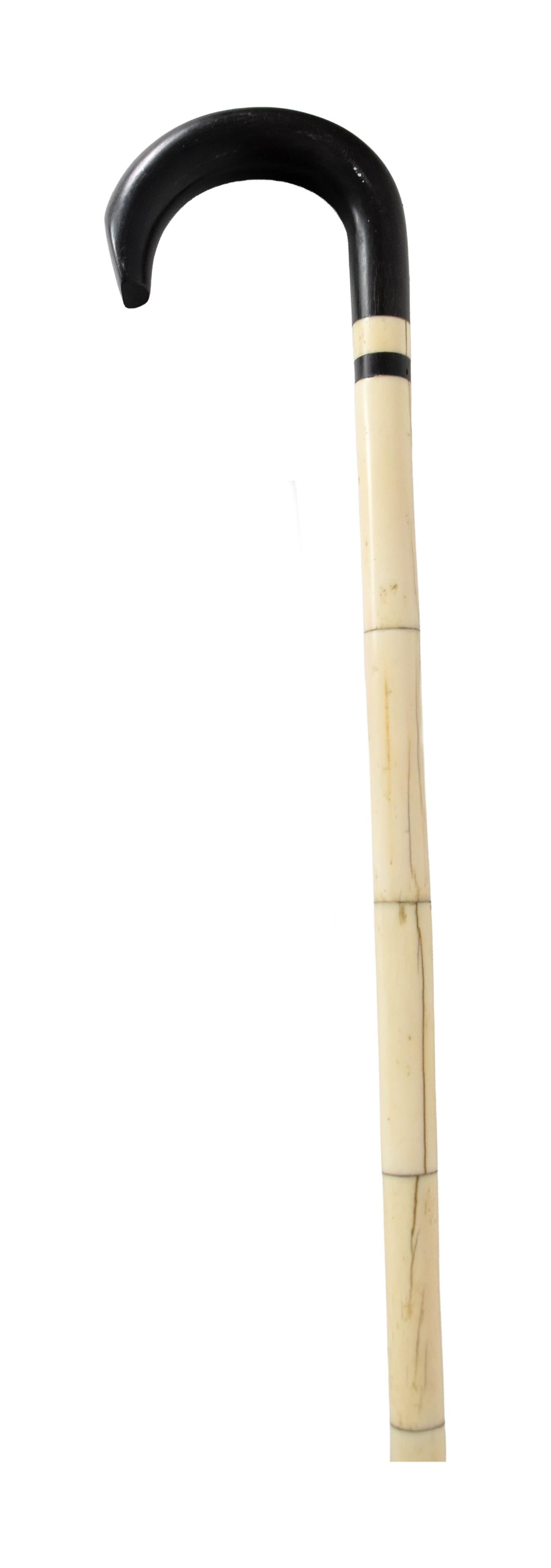 Sailor Made Scrimshaw Walking Stick: 19th C. Ebony handle. Baleen band. Carved and segmented whalebone shaft. Nantucket Island provenance.Shows some age separation in bone bands. Shipping restriction: Please note this lot cannot be