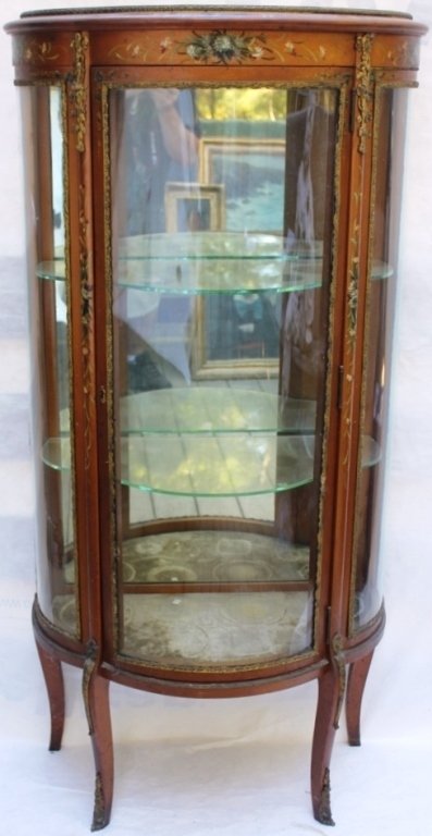 EARLY 20TH C CURIO CABINET, MIRRORED BACK,: GLASS SHELVES, ONE HAS CHIP, CURVED SIDES AND FRONT, HAND PAINTED FLORAL DESIGN, GILT BRASS TRIM (SOME TRIM IS LOOSE), 55" HIGH, 26" WIDE, 13" DEEP.