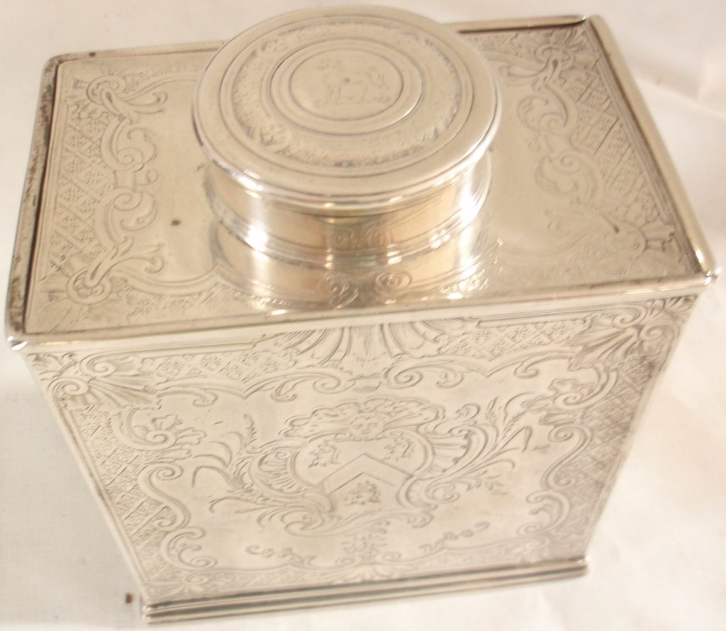 ENGLISH STERLING SILVER TEA CADDY WITH SLIDING TOP: DELICATELY CHASED ARMORIAL DECORATION. BASE IS MARKED WITH THE LION PASSANT, CROWNED LEOPARD'S HEAD, UPPER CASE LETTER P, A MAKER'S MARK OF A CROWN WITH THE LETTERS B O G AND THE DATE OF 1716. THE BOT