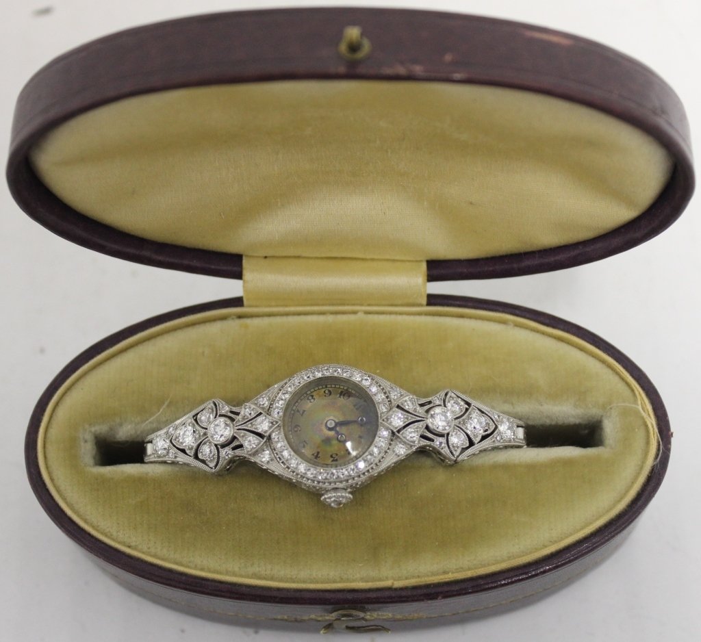 ART DECO PLATINUM LADIES WRISTWATCH SET WITH: DIAMONDS; MOVEMENT STAMPED MERIMONT WATCH CO., SWISS, 18 JEWELS; DIAMONDS SURROUND WATCH FACE AND SIDE MOUNTS INCLUDING A .20 DIAMOND ON EACH SIDE; UNMARKED BAND TESTS 14K GOLD; 13.8 DWT WITHOUT MOVEM