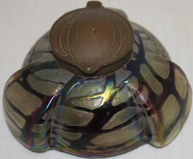 AUSTRIAN ART GLASS INKWELL POSSIBLY LOETZ,: SHAPED BRASS COVER, CLEAR GLASS INSERT HAS A RIM CHIP, UNSIGNED, 2 3/4" HIGH, 4 1/2" DIAMETER.