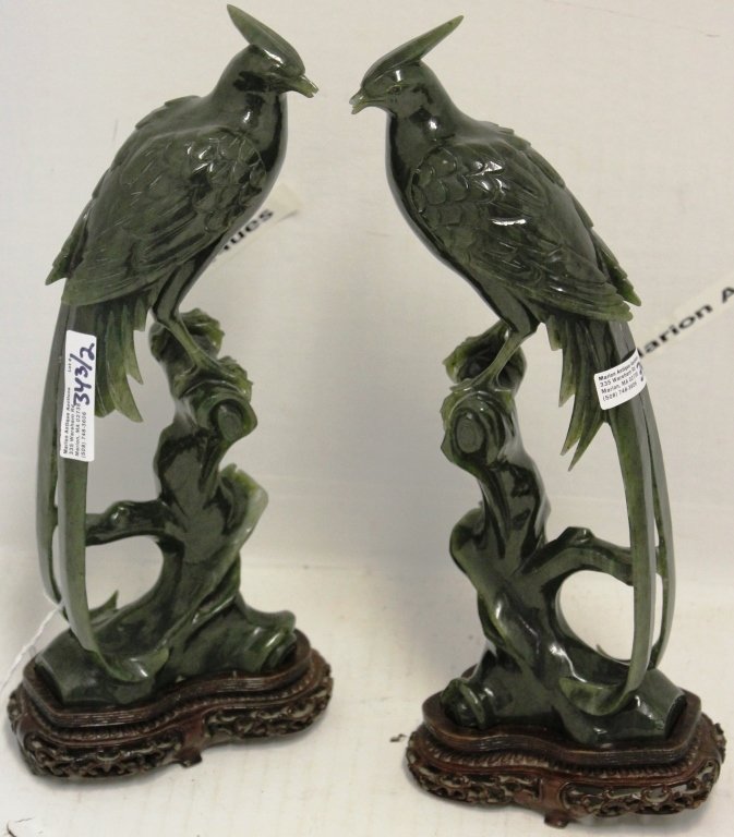 PAIR OF CARVED GREEN BIRDS, PROBABLY JADE, SHOWS: DAMAGE TO BEAKS ON BOTH BIRDS, 10" HIGH. EACH WITH TEAK WOOD BASE.