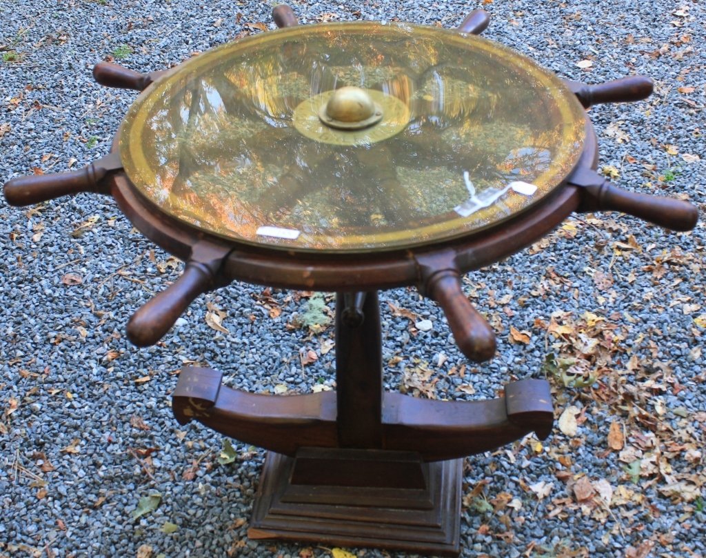20TH C SHIP'S WHEEL TABLE, BRASS RING,: JOHN HASTIE & CO. LIMITED, GREENOCK, SCOTLAND. CUSTOM ANCHOR FORM BASE. 29 1/2" HIGH, 36" DIAMETER. CHIP TO BASE.