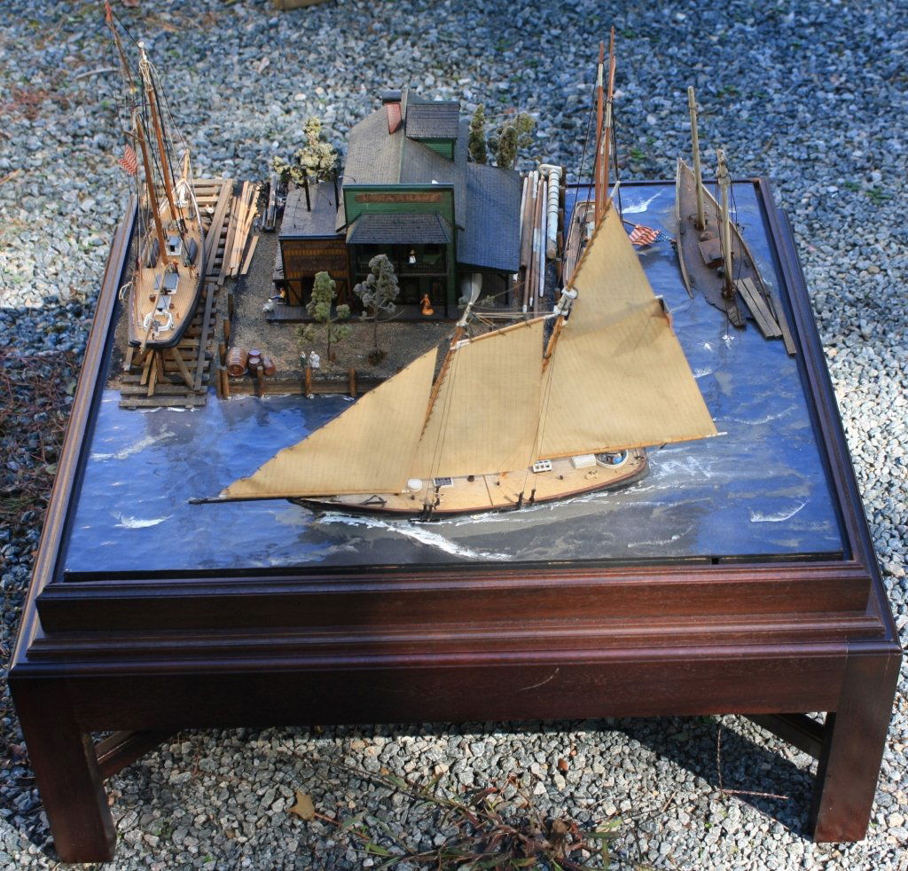 20TH C NAUTICAL DIORAMA DEPICTING AN EARLY 19TH C: VIEW OF INDIA WHARF (IN BOSTON) WITH BUILDINGS AND SHIPS IN A CUSTOM MADE MAHOGANY CASE AND CUSTOM MADE BASE. 28 1/2" HIGH, 27 1/2" WIDE, 24" DEEP. SHOWS MINOR DAMAGE.