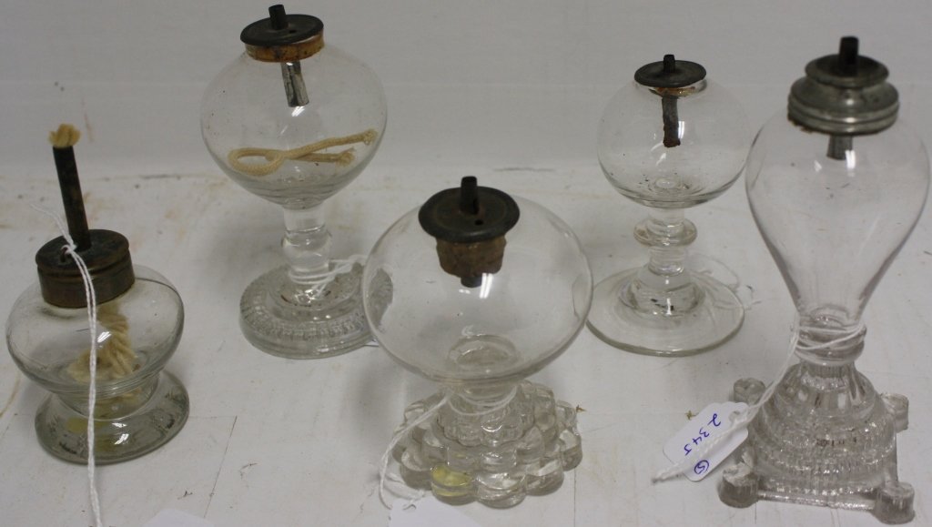 5 RARE 19TH C MINIATURE GLASS WHALE OIL LAMPS,: 4" TO 5" TALL. 2 HAVE STEPPED BASES. POSSIBLY SANDWICH GLASS CO. ALL 5 HAVE THEIR ORIGINAL BURNERS. ONE BASE SHOWS SLIGHT CHIPS ON FOOT.