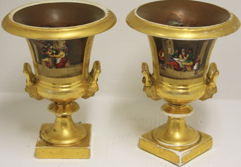 PAIR OF 19TH C PARIS PORCELAIN URNS WITH CUSTOM: MADE COPPER INSERTS. CLASSICAL FIGURAL HANDLES. PAINTED WITH LANDSCAPE AND FESTIVE DRINKING SCENES. 10" HIGH. SHOWS WEAR TO GOLD PAINT.