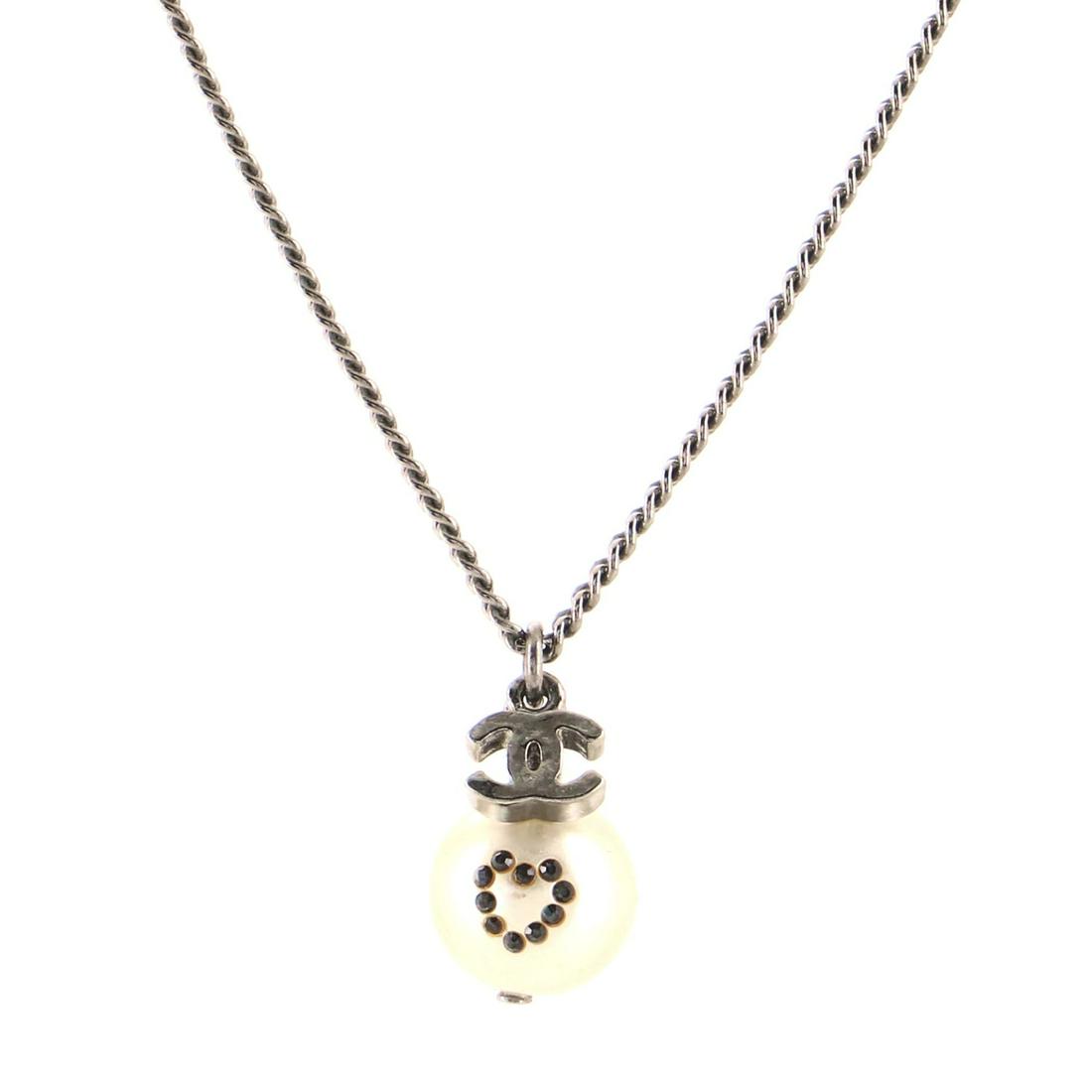 Chanel CC Crystal Heart Drop Pearl Necklace Crystal: Chanel CC Crystal Heart Drop Pearl Necklace Crystal Embellished Faux Pearl and Metal Exterior Color: Silver Material: Crystal, Faux Pearl, Gun Metal Item No: 103225/232 Brand Code: 08 P SIZE AND FIT: 