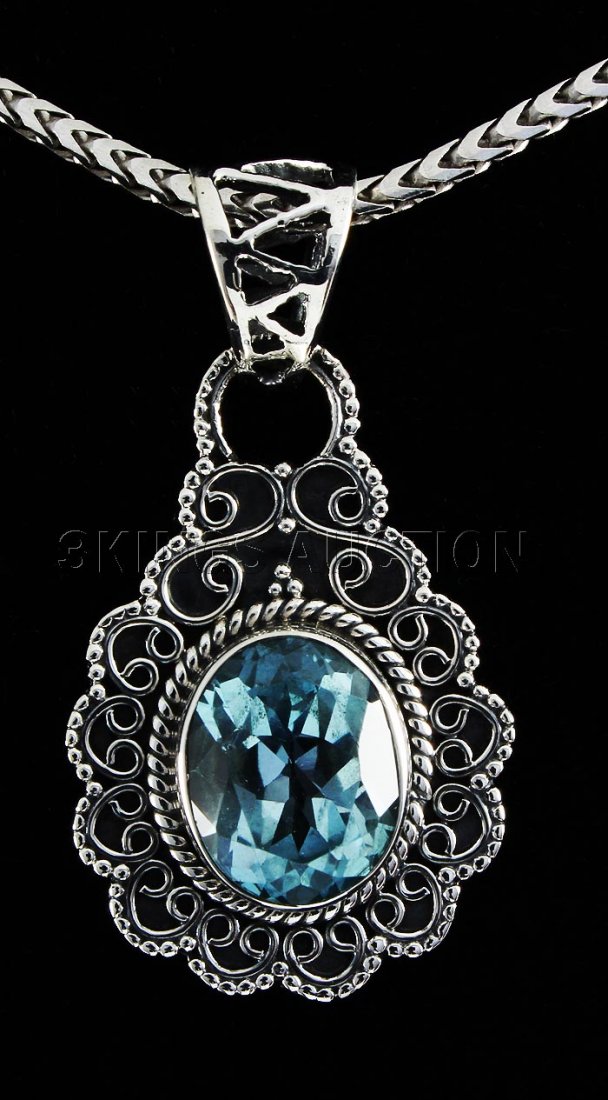 4.50CT Oval Blue Topaz Antique Design .925 Pendant 3.60: 4.50CT Oval Blue Topaz Antique Design .925 Pendant 3.60 **|**|** 1.29in. Long Sterling Silver Pendant with a Blue Topaz Faceted Gem Measuring 11x9mm Oval ; MSRP: $300