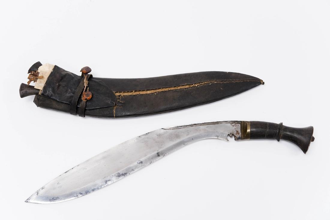 Nepalese Kukri with Scabbard.: 19th Century Nepalese Kukri with leather wrapped wood scabbard. Curved fifteen inch blade with typical karda notch at base of blade. Bone or horn handle with brass butt plate. Scabbard holds 2 small b
