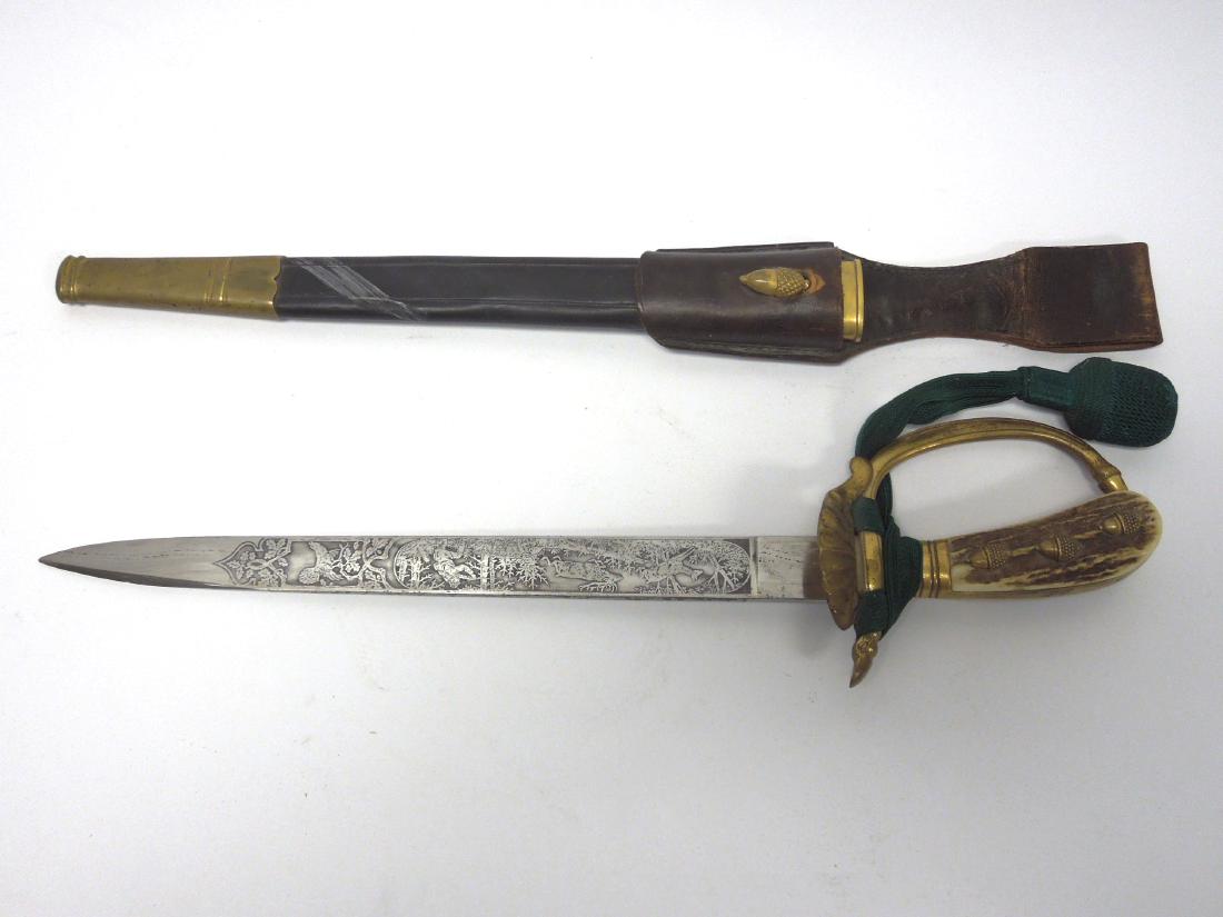 German Hunting Dagger, Carl Eickhorn.: German hunting dagger with sheath. Marked Original Eickhorn Solingen. 12 3/4 inch blade with hunting scenes on each side. Shell form gilt metal guard. Bone handle with acorn medallion decorations. She