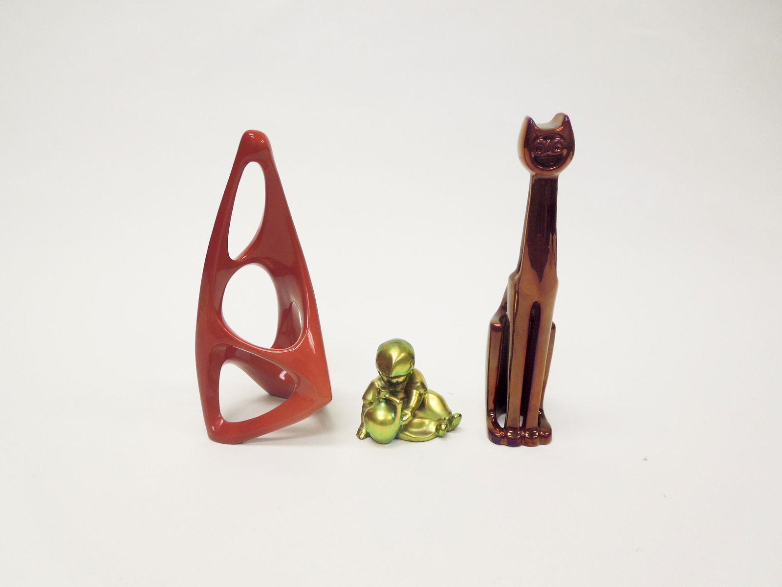 (3) Zsolnay Hungary Porcelain Figures.: (3) Zsolnay Hungary porcelain figures. Red Eosin glazed tall, seated cat, Green Eosin glazed seated girl with a pitcher and an abstract figure. (9 1/4", 3" & 9" inches tall).