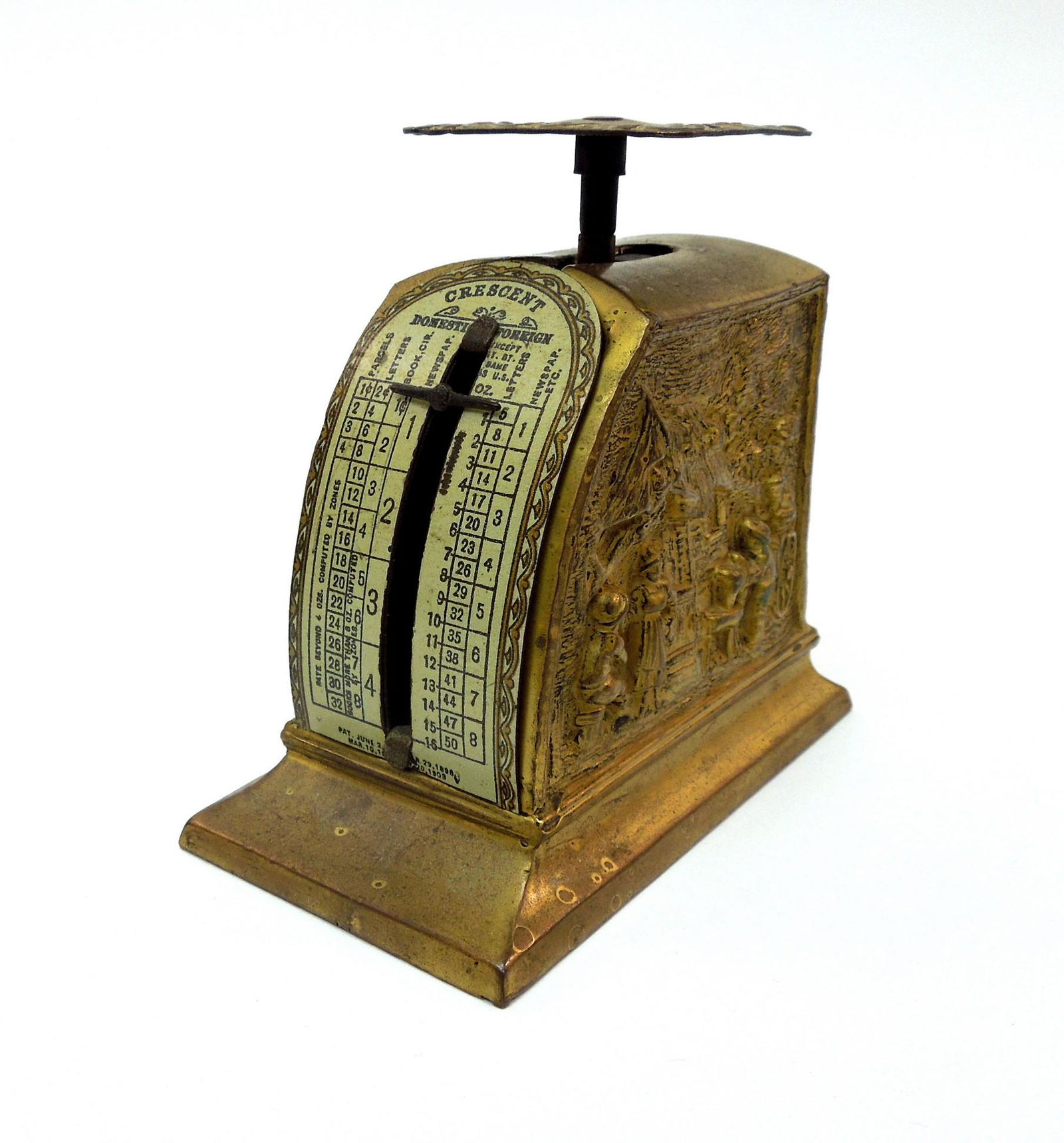 Bronze Postage Scale Circa 1920s.: Circa 1920s Bronze postage scale. Relief carved village scenes on the side. The bottom in a cobble pattern with the letters JB and the numeral 1330 stamped. Postage meter plate marked Crescent. 3 1/2