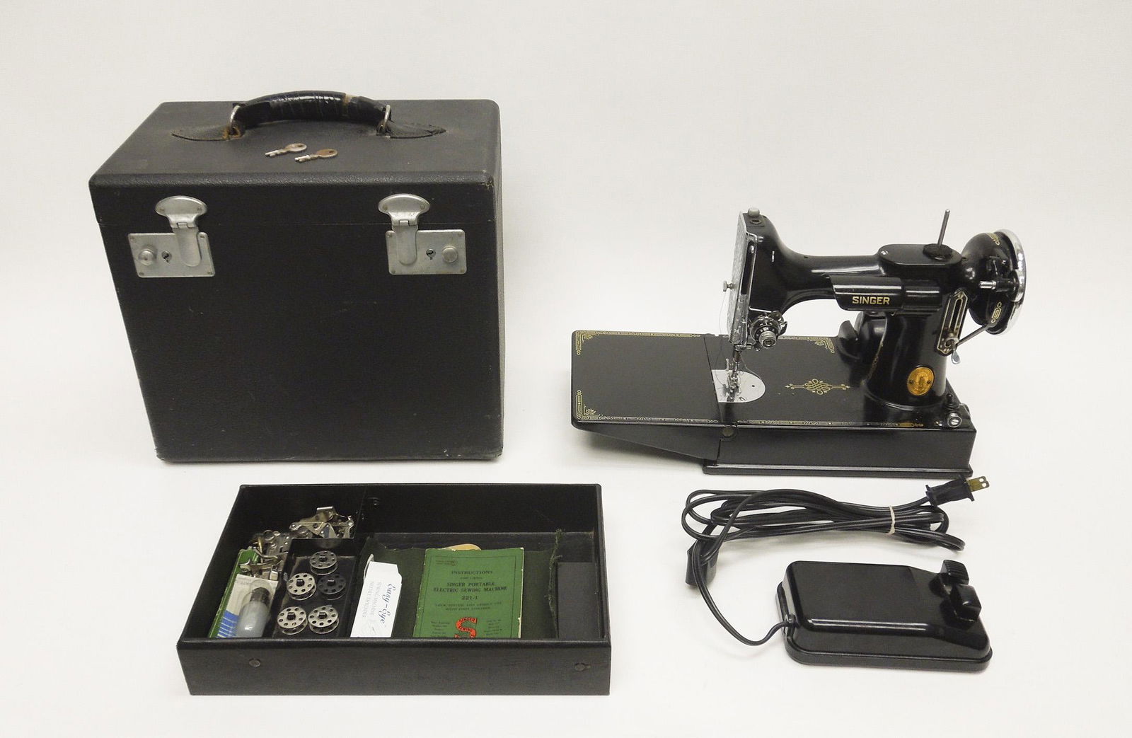 Singer 221 Featherweight Sewing Machine.: Singer 221 Featherweight sewing machine with bobbin, travel case, foot pedal and other accessories including Ruffler, Seam guide, Tucker.