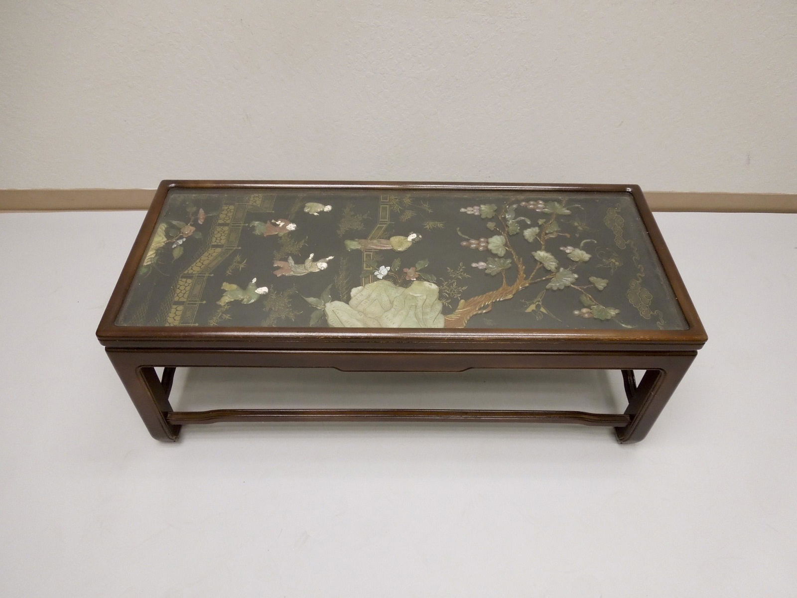Chinese Coffee Table with Jade & Hard Stone Decoration.: Chinese hard wood coffee table with carved jade and hard stone landscape decoration and glass top. 48.5" L, 20.5" W, 18" H.