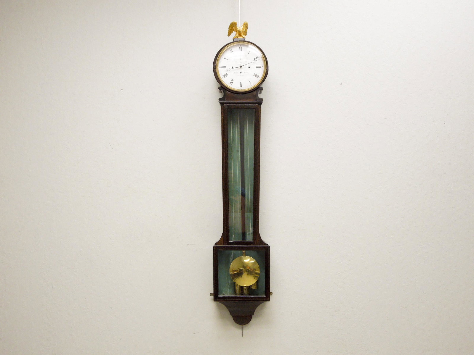 19th C. Josef Wesely Wall Clock.: 19th C. Josef Wesely wall clock. Mahogany case clock with gilt wood eagle finial. Circular enameled dial marked Josef Wesely In Hoen, with Roman numeral indicators. Overall: 56" x 12".