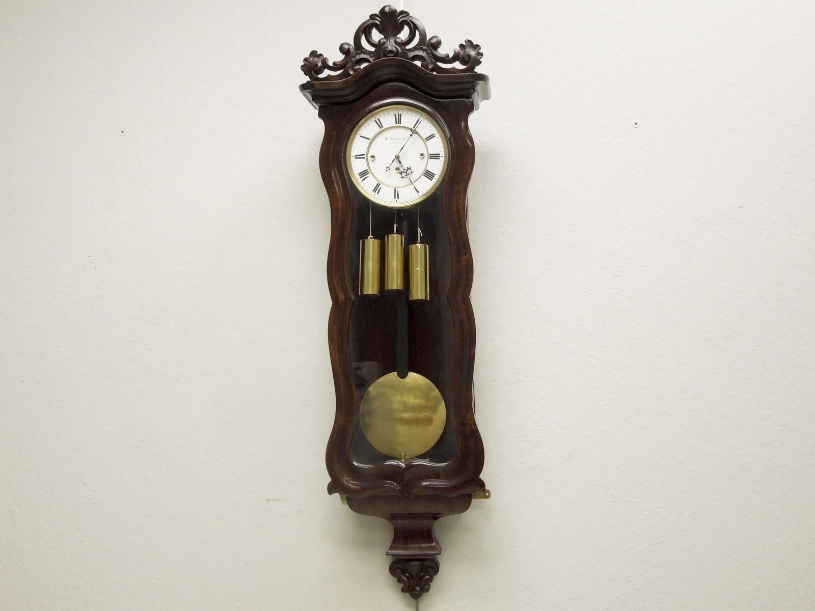 19th C. Schoneberger Austrian Wall Clock.: W. Schonberger Austrian wall clock, 19th C. Walnut case clock with enameled dial marked W. Schonberger In Wien with Roman numeral indicators. Overall: 45" x 15".
