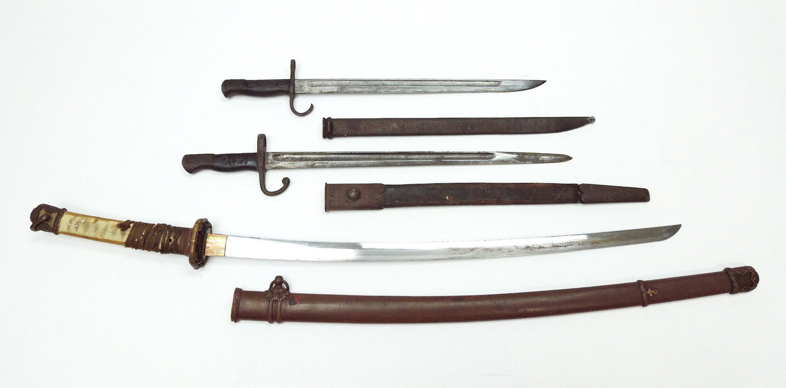Imperial Japanese Sword and Bayonets.: Imperial Japanese sword and bayonets. World War II NCO sword with scabbard and (2) period rifle bayonets with leather sheaths. Sword: 26" blade, 36" overall; Bayonets: 18" & 15 1/2" blades, 22 3/4" & 