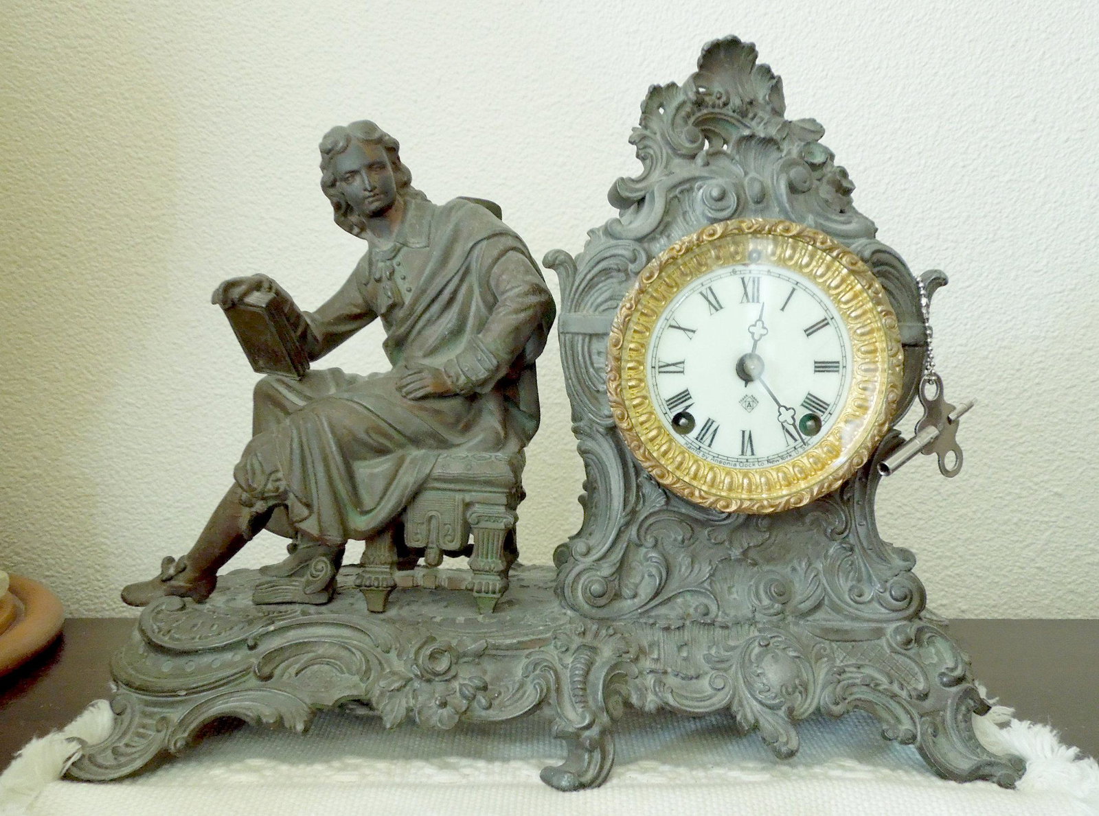 Late 19th / Early 20th C. Ansonia Mantel Clock.: Late 19th / early 20th C. Ansonia mantel clock. Seated scholar spelter figure with rococo sea scroll and foliate base. 11" x 14" x 5".