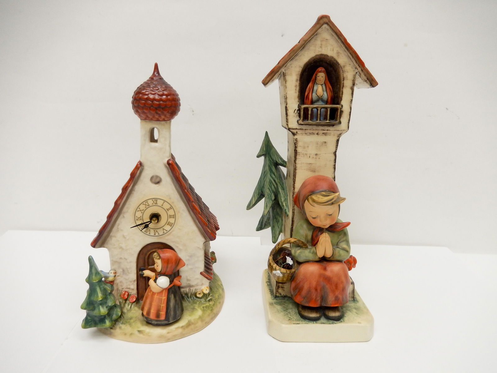 Two Hummel Figural Groups.: Two Hummel figural groups, Goebel W. Germany "Chapel Time Bergkirchlein",MJ Hummel signed, Ely 6 xx, "The Love Lives On". "Worship", girl at prayer beneath tower. H: 13 inches.