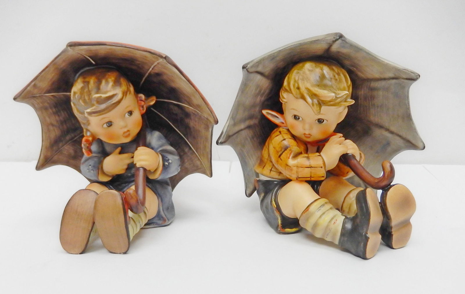 Pair of Hummel Umbrella Figures.: Two Hummel figures: Umbrella Boy and Umbrella Girl. Goebel W. Germany. Signed, dated 1987. Height 5 inches.
