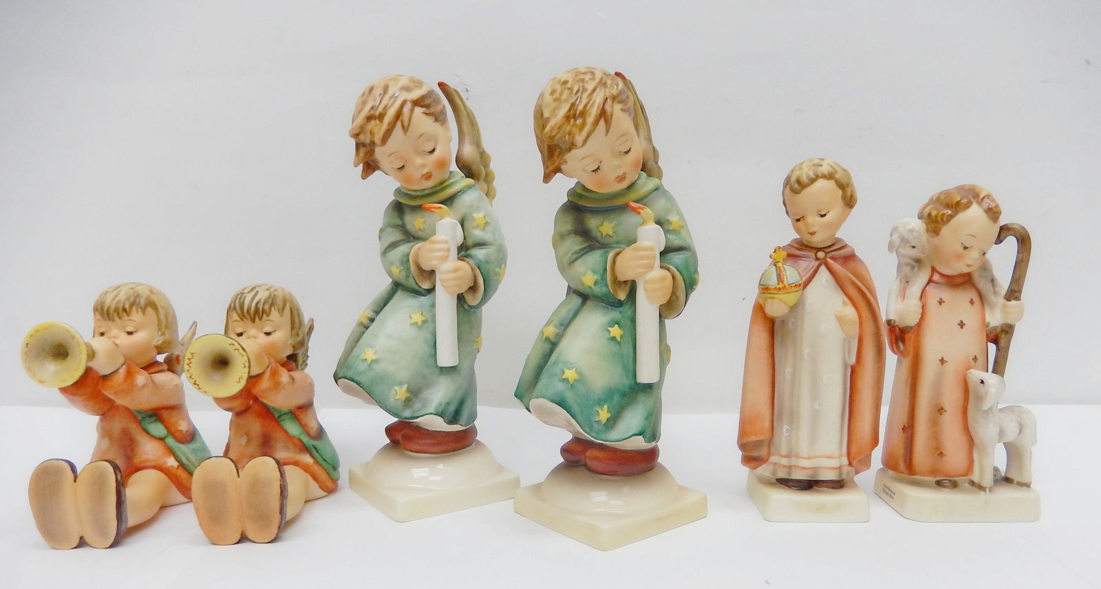 Three pairs of Hummel Figurines.: Three pairs of Hummel Figurines, Goebel W. Germany: Pair "Little Gabriel" seated angels with trumpets. 27/III H: 5 inches. Pair "Heavenly Angel" angels standing with candlestick, 2/II H: 8.5 inches. P