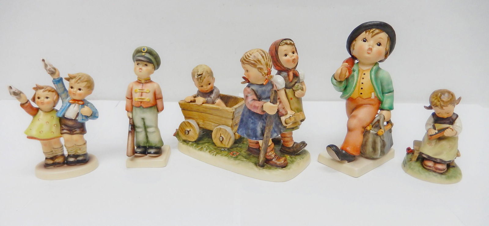 Five Hummel Figures and Groups.: Five Hummel figures and groups, Goebel W. Germany: "Busy Student", 4 in.; "Merry Wanderer", 7 in.; "Pleasant Journey", 7 x 7 in.; "Soldier Boy", 6 in.; "Auf Viedersehen", 6 in.