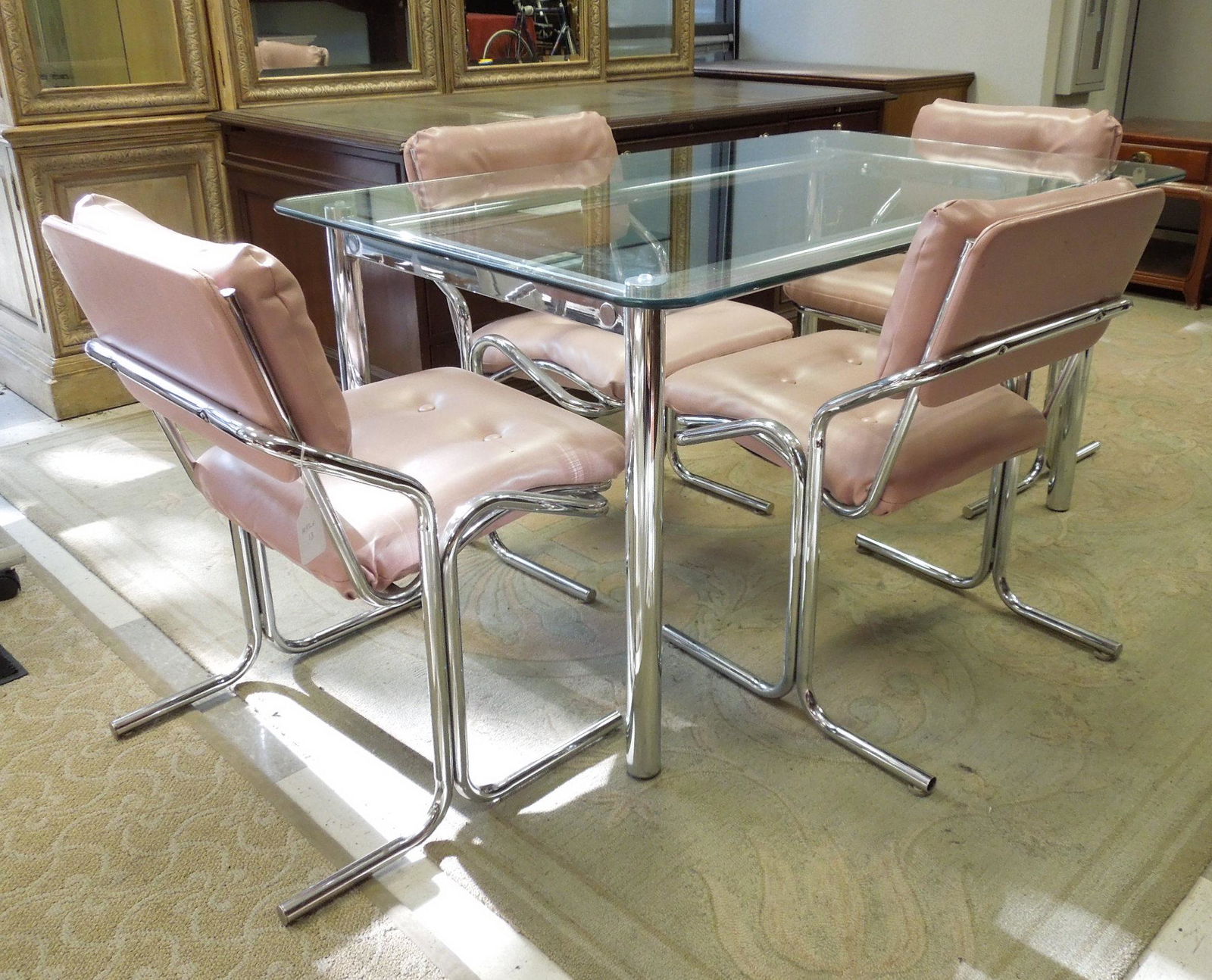 Modernist Chrome and Glass Dining Table & Chairs.: Modernist chrome and glass top dining table with four (4) chrome chairs with pink vinyl upholstery. Approximate dimensions: table 5' x 3', chairs 22.5" W x 23" D x 33" H .