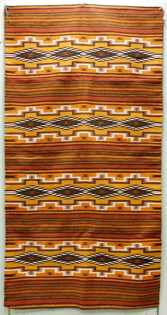 Navajo Handwoven Wide Ruins Rug.: Navajo handwoven Wide Ruins rug. Contrasting colors of Mustard, Saffron, brown, rust, white and others. 79.5" x 42". Richardson Trading Co. tag indicates Donald Wood as the weaver.