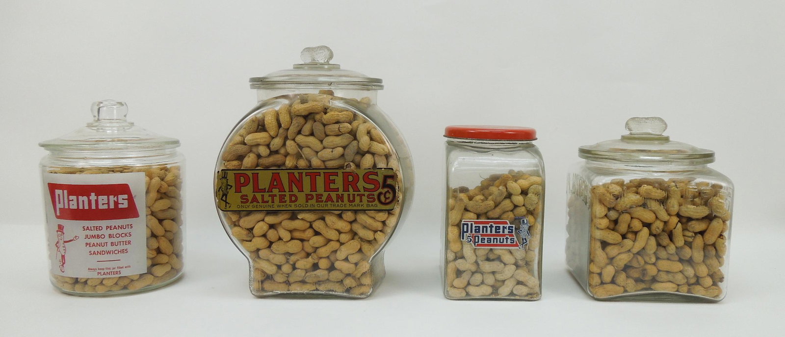 (4) Vintage Planters Peanuts Store Glass Canisters.: (4) Vintage Planters Peanuts store glass canisters with original lids.