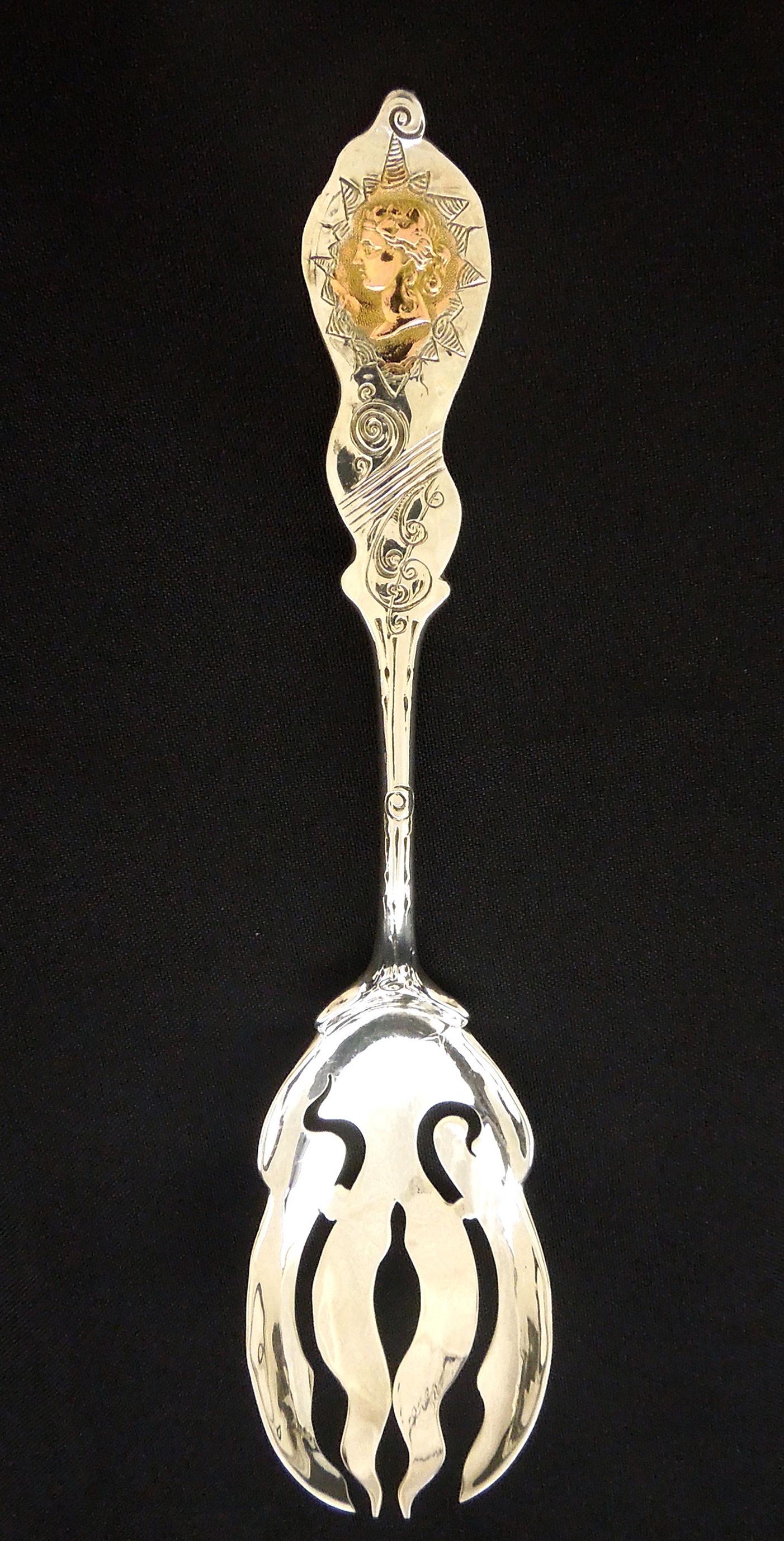 Sterling Silver & 14K Serving Fork.: Sterling Silver and 14K fancy serving fork. Winged eagle with 'S' silver mark, profile of a woman in 14K yellow gold. 9 1/4 inches long, 3.41 troy oz.